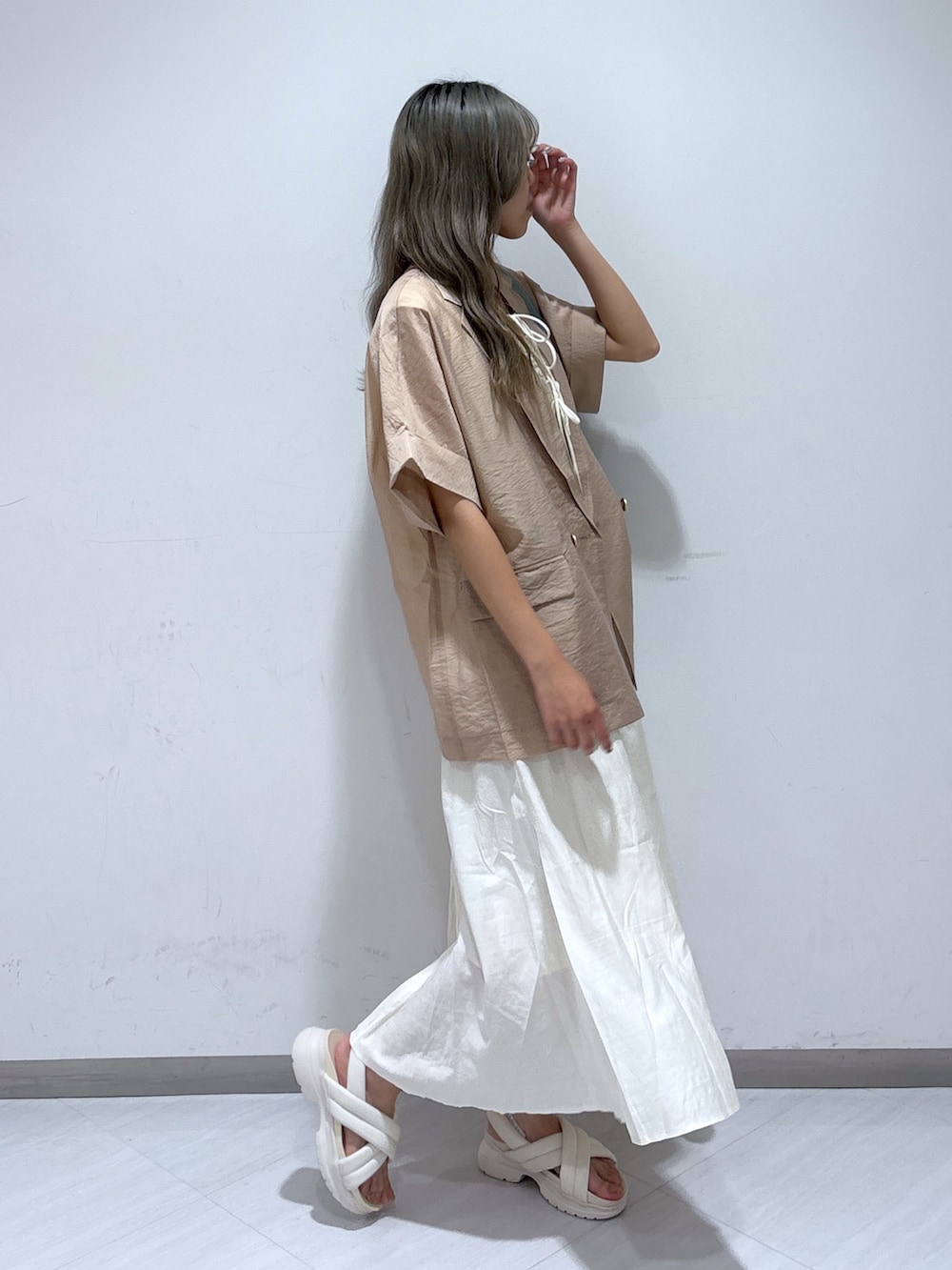 ホワイト系のワンピース、ベージュ系のテーラードジャケット、ブルー系のショルダーバッグを着用したレディースの夏コーディネートの3枚目の写真