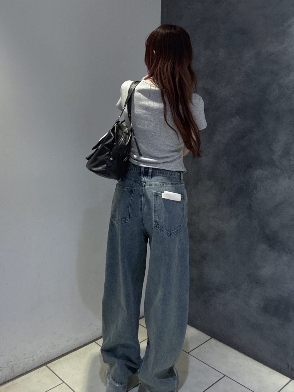 ブラック系のショルダーバッグ、グレー系のTシャツ/カットソー、ブルー系のデニムパンツを着用したレディースの夏コーディネートの6枚目の写真