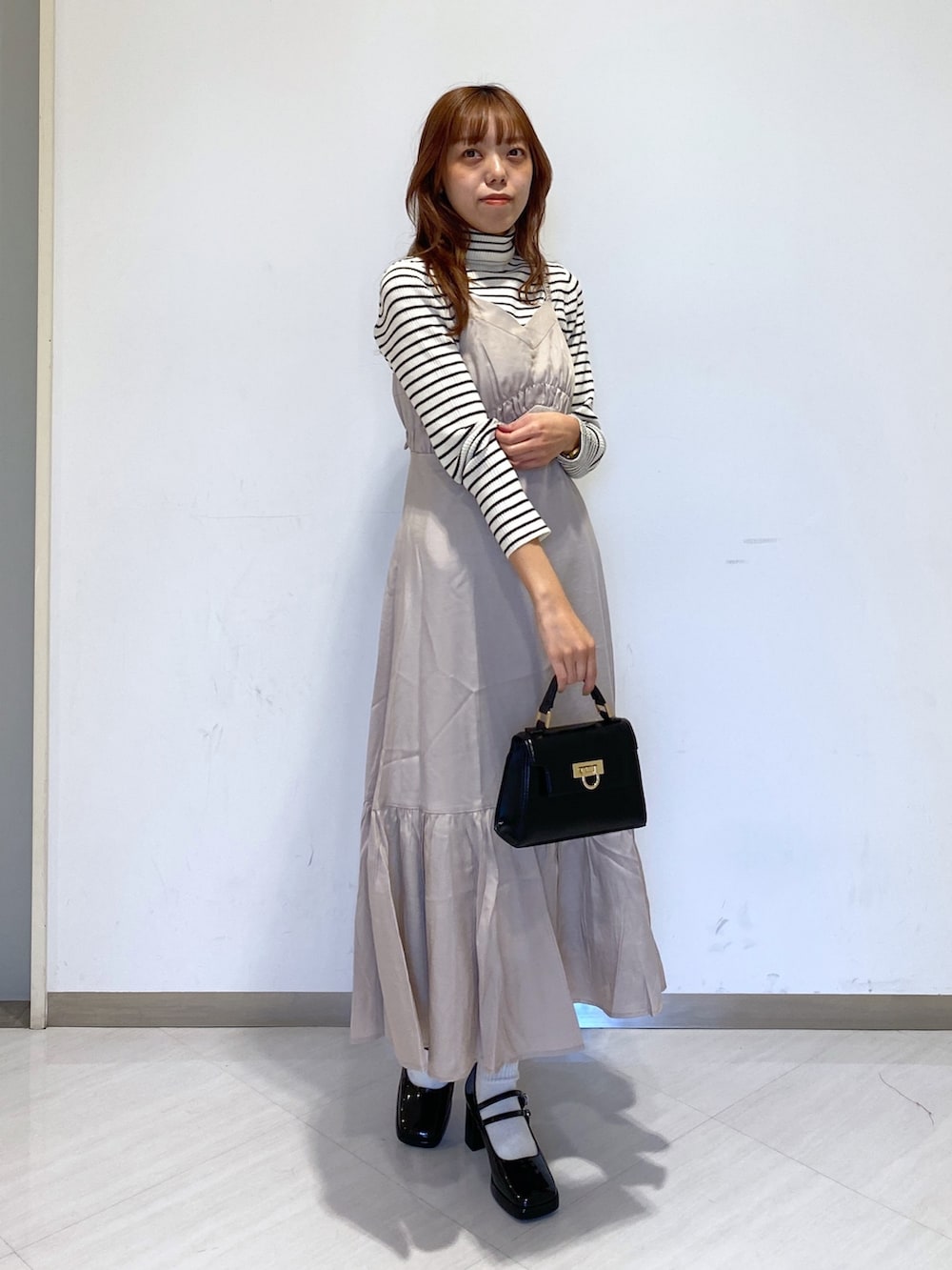 ホワイト系のニット/セーター、ブラック系のショルダーバッグ、ブラック系のパンプスを着用したレディースの秋コーディネートの2枚目の写真