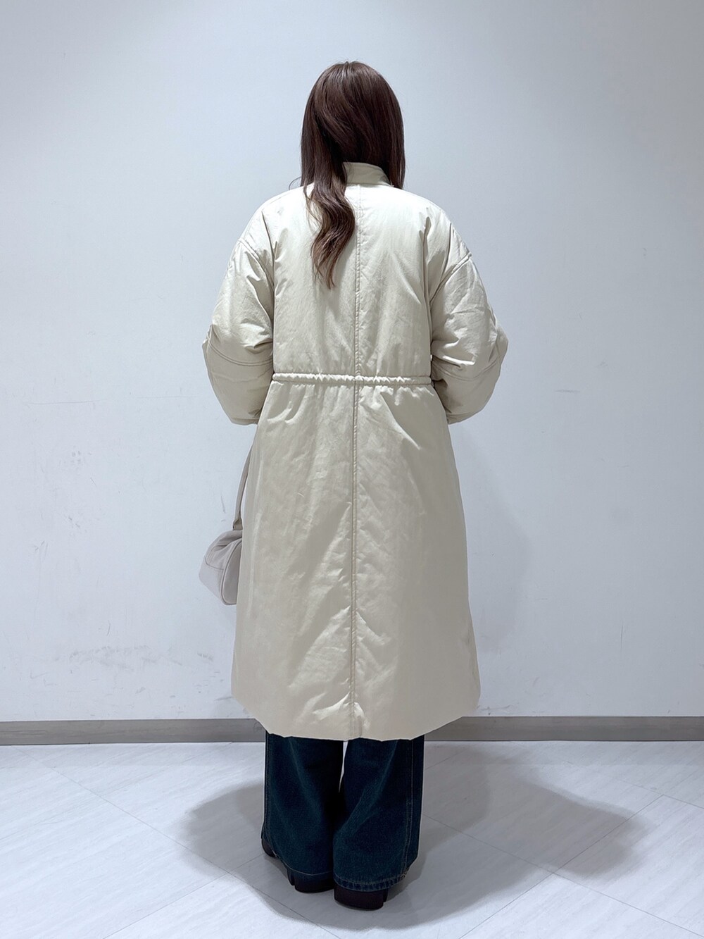 ホワイト系のその他アウター、ベージュ系のニット/セーター、ブルー系のデニムパンツを着用したレディースの冬コーディネートの5枚目の写真