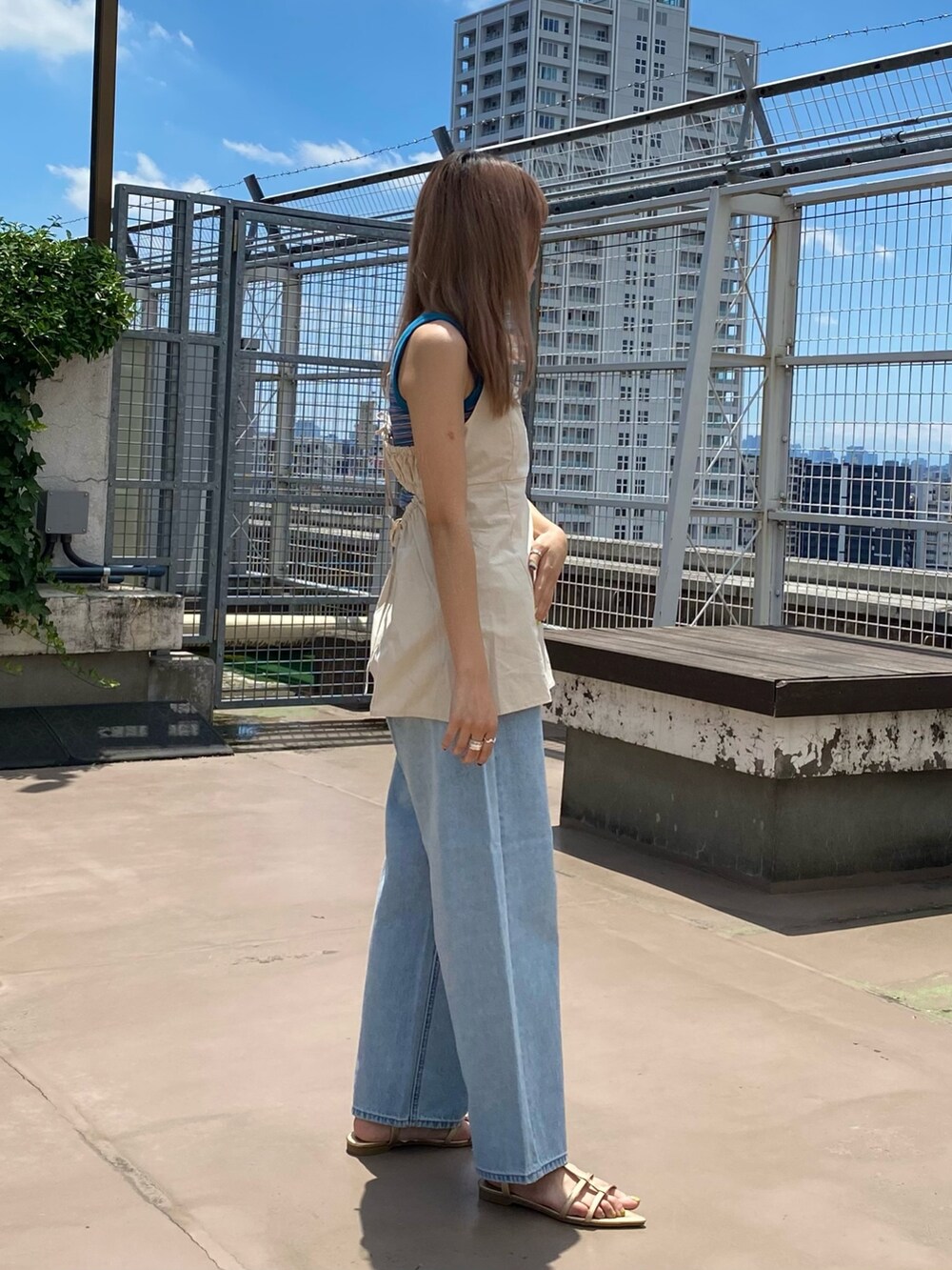 ベージュ系のシャツ/ブラウス、パープル系のタンクトップ、ブルー系のデニムパンツを着用したレディースの夏コーディネートの2枚目の写真