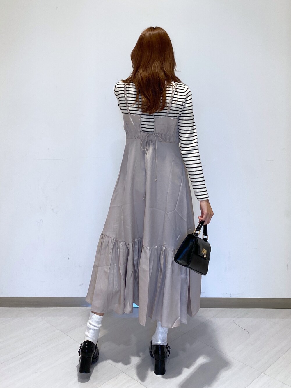 ホワイト系のニット/セーター、ブラック系のショルダーバッグ、ブラック系のパンプスを着用したレディースの秋コーディネートの3枚目の写真