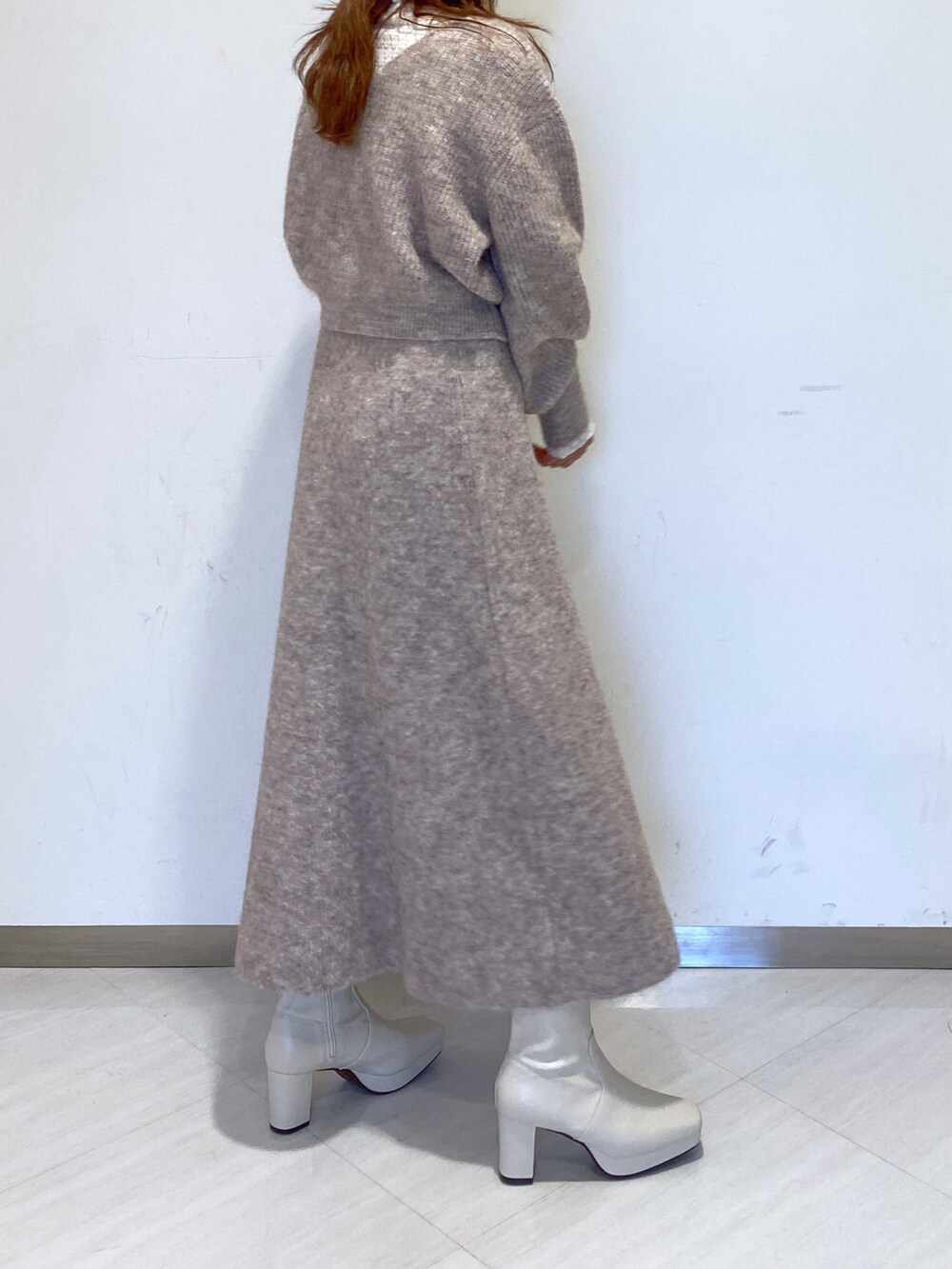 ホワイト系のブーツ、ホワイト系のTシャツ/カットソー、ベージュ系のニット/セーターを着用したレディースの秋コーディネートの2枚目の写真