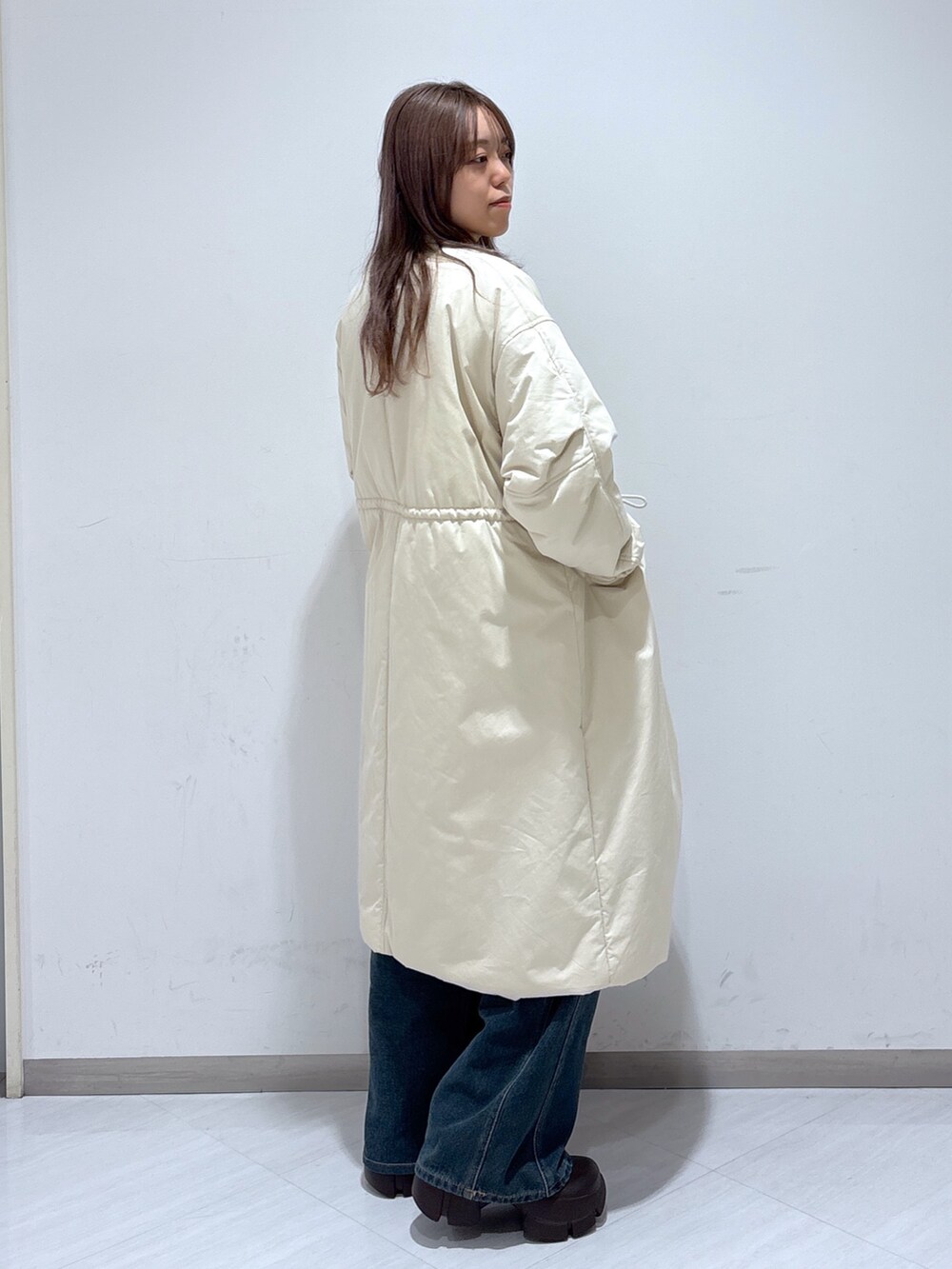 ホワイト系のその他アウター、ベージュ系のニット/セーター、ブルー系のデニムパンツを着用したレディースの冬コーディネートの3枚目の写真
