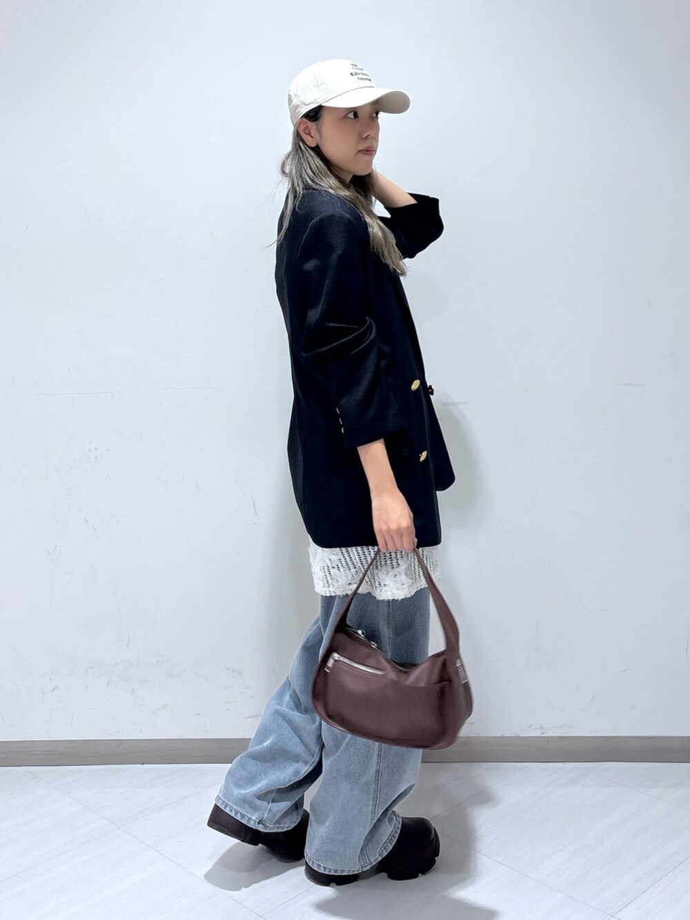 ブルー系のテーラードジャケット、ホワイト系のワンピース、ブルー系のデニムパンツを着用したレディースの夏コーディネートの4枚目の写真