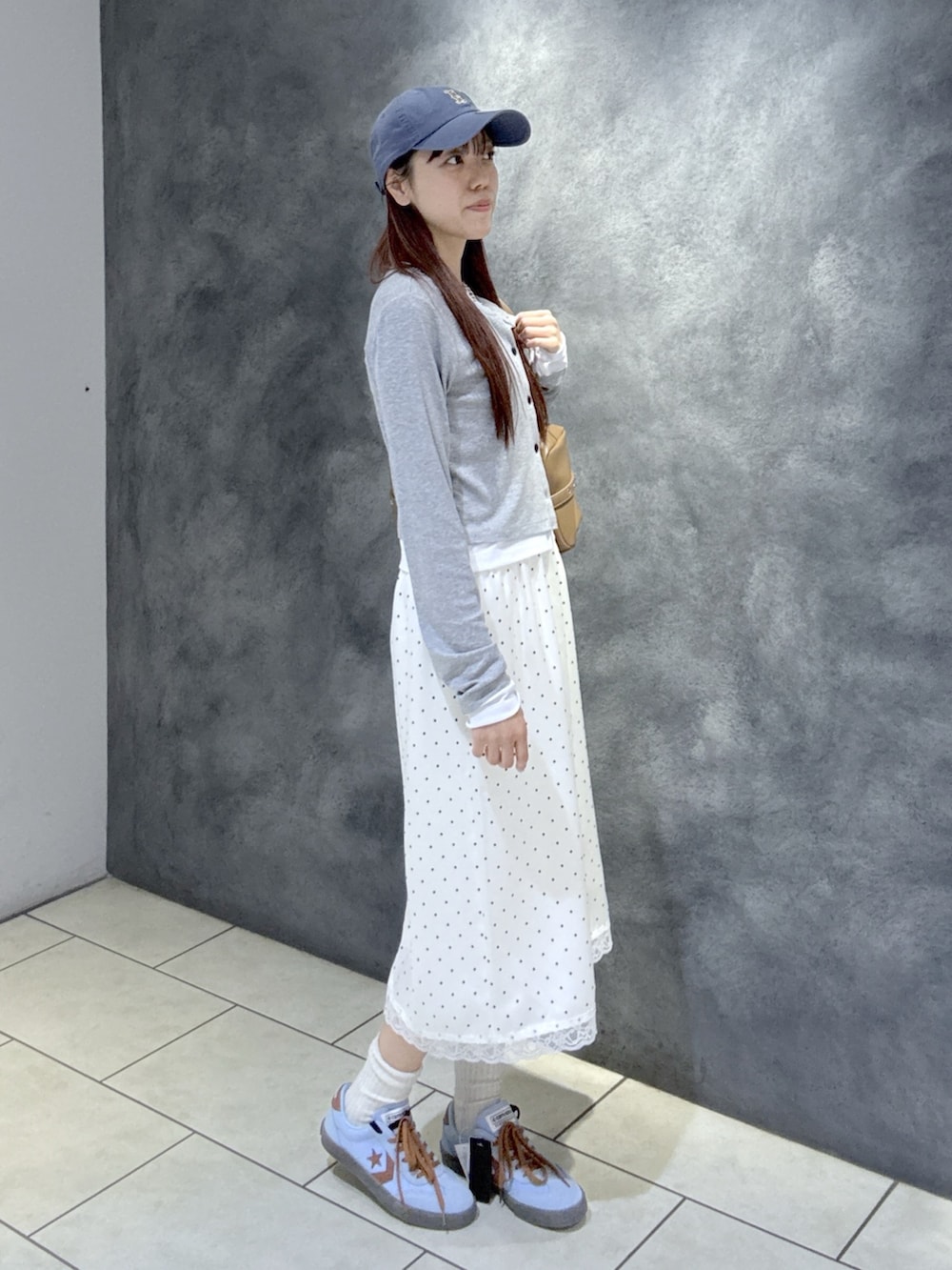 グレー系のTシャツ/カットソー、ブラウン系のショルダーバッグ、ブルー系のスニーカーを着用したレディースの春コーディネートの3枚目の写真