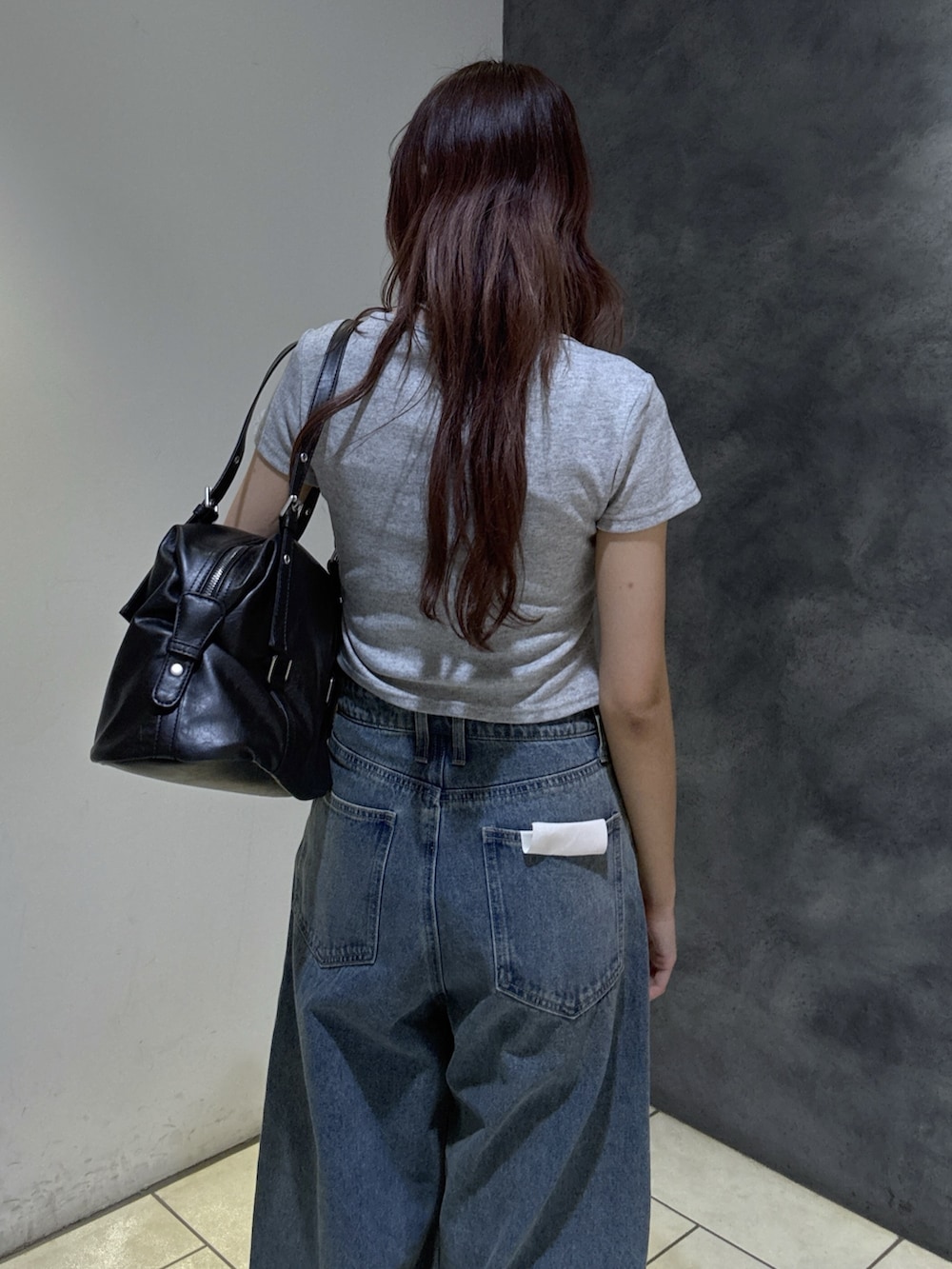 ブラック系のショルダーバッグ、グレー系のTシャツ/カットソー、ブルー系のデニムパンツを着用したレディースの夏コーディネートの7枚目の写真