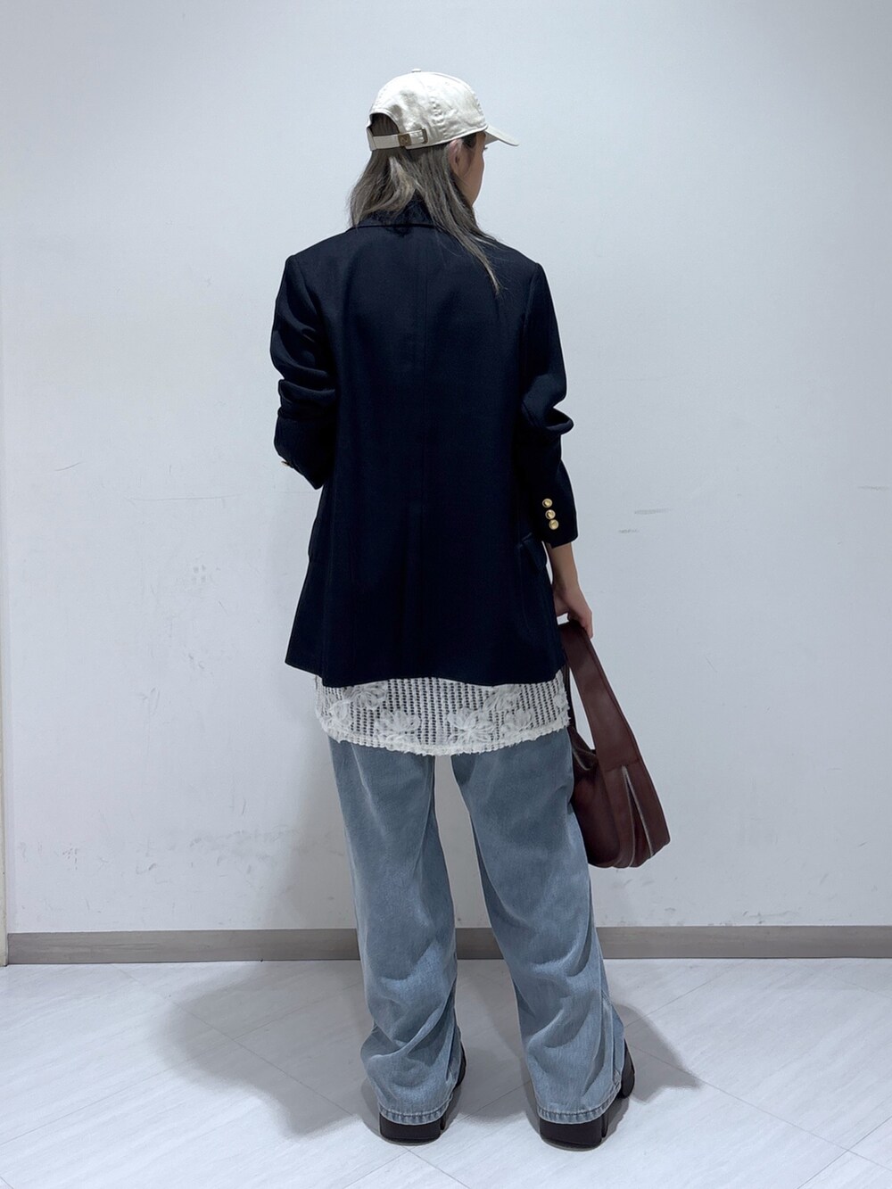 ブルー系のテーラードジャケット、ホワイト系のワンピース、ブルー系のデニムパンツを着用したレディースの夏コーディネートの5枚目の写真