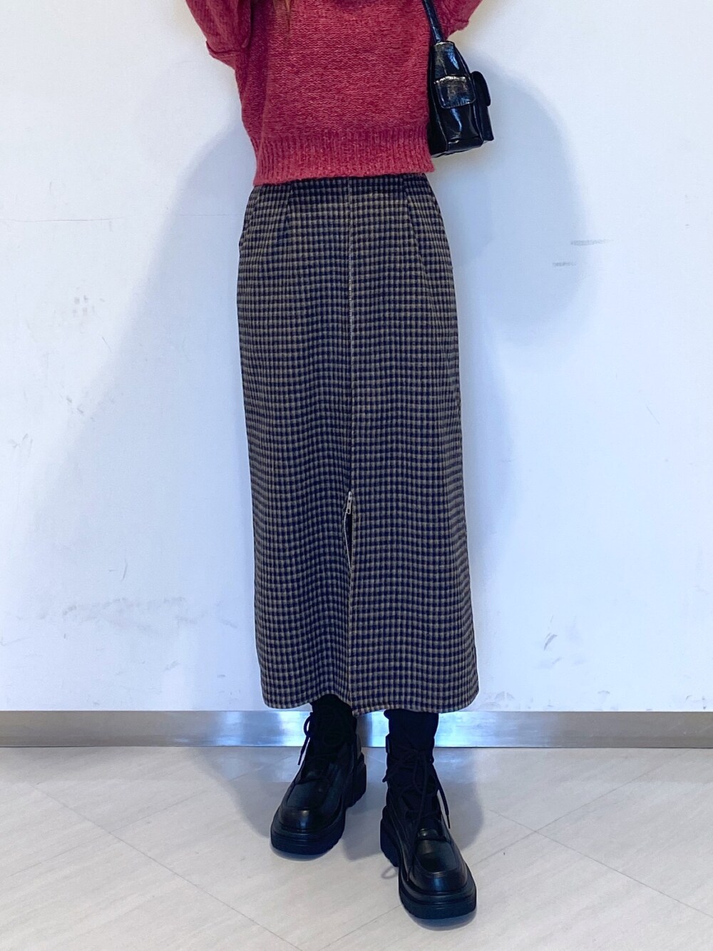 ブラック系のブーツ、ブラック系のハンドバッグ、ピンク系のニット/セーターを着用したレディースの秋コーディネートの6枚目の写真