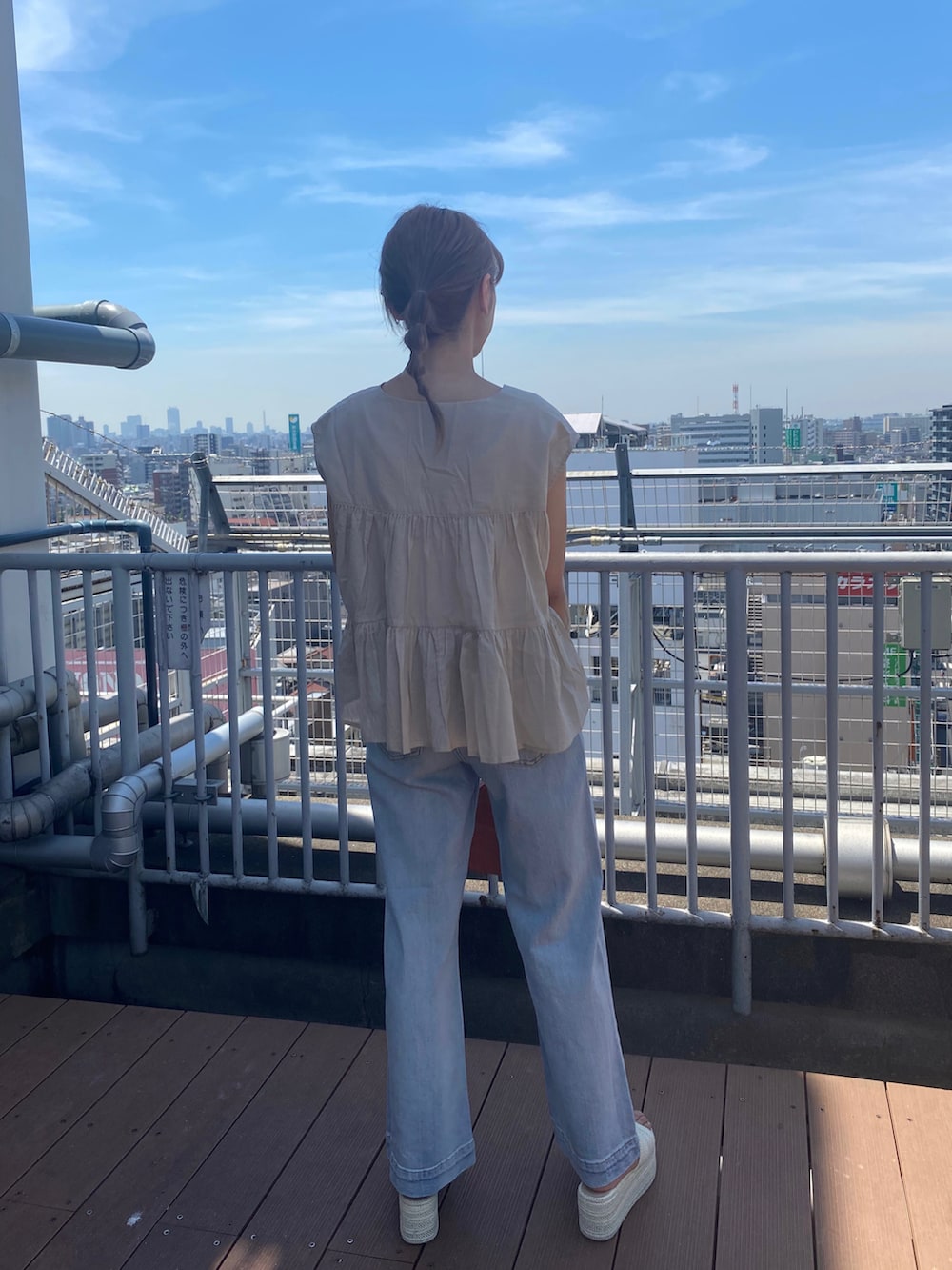 ホワイト系のサンダル、ブルー系のデニムパンツ、オレンジ系のハンドバッグを着用したレディースの夏コーディネートの4枚目の写真