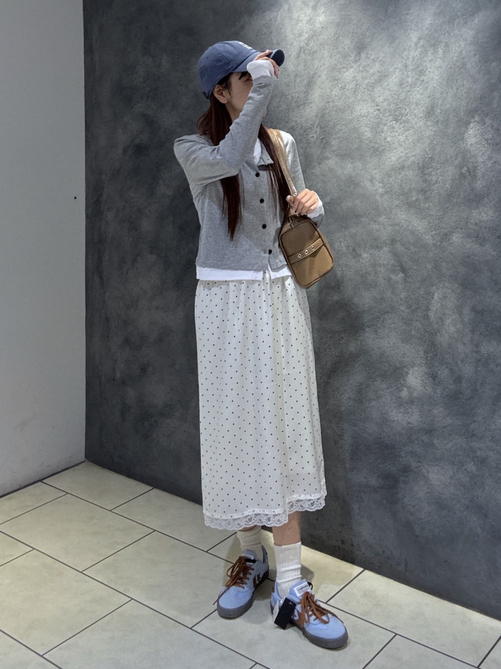 グレー系のTシャツ/カットソー、ブラウン系のショルダーバッグ、ブルー系のスニーカーを着用したレディースの春コーディネートの5枚目の写真