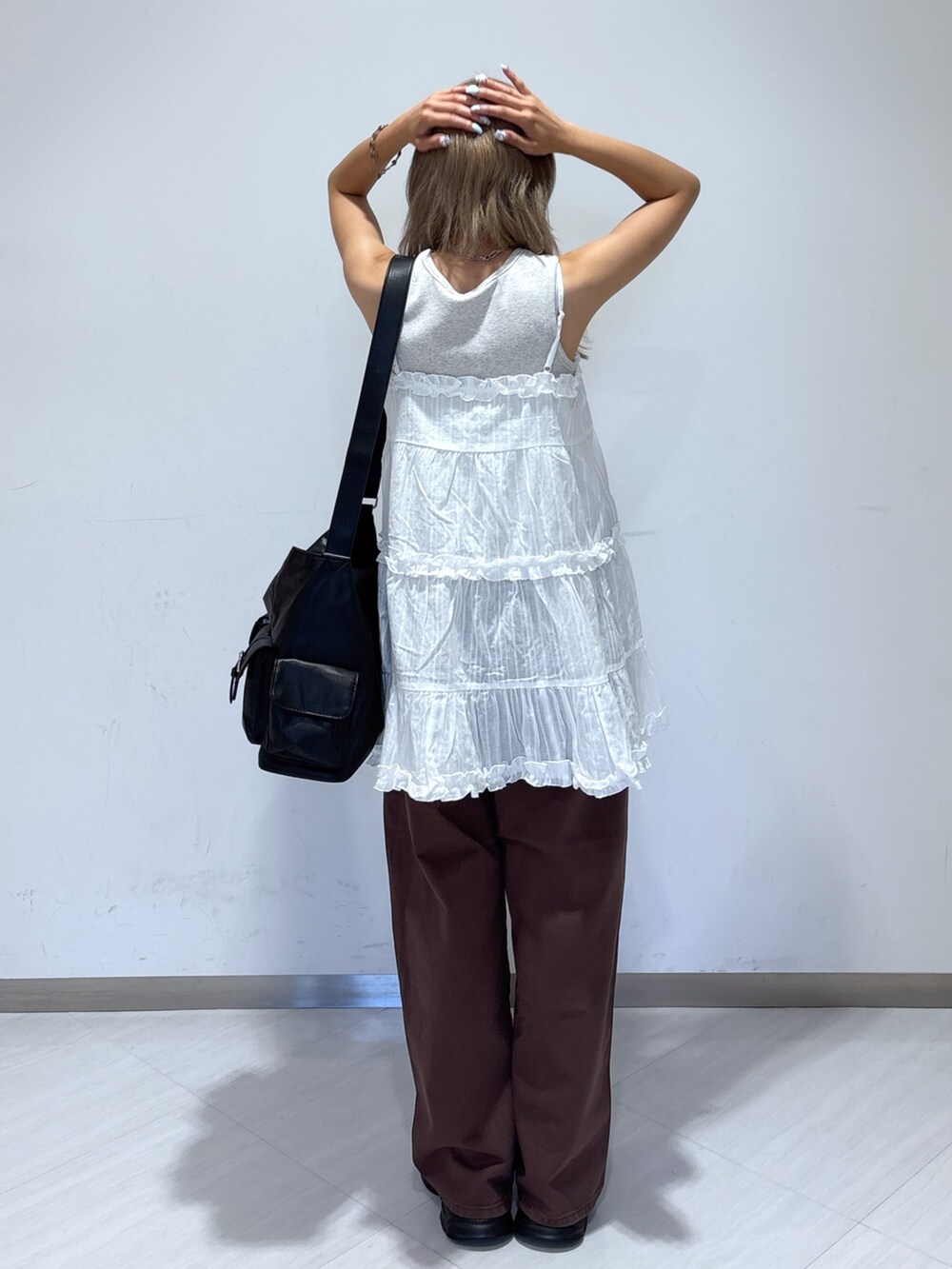 ブラウン系のデニムパンツ、ホワイト系のワンピース、ホワイト系のスニーカーを着用したレディースの夏コーディネートの3枚目の写真