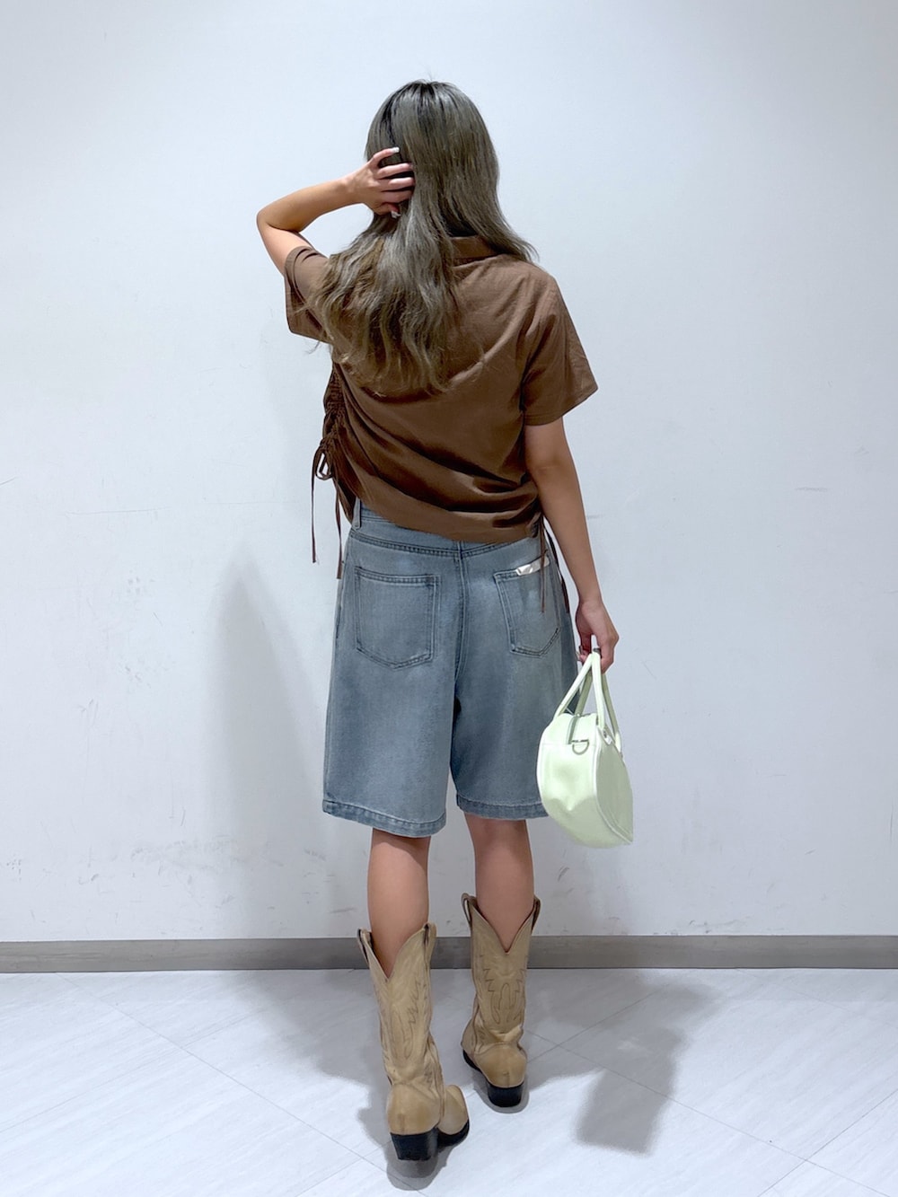 ブルー系のデニムパンツ、グリーン系のトートバッグ、ブラウン系のシャツ/ブラウスを着用したレディースの夏コーディネートの4枚目の写真