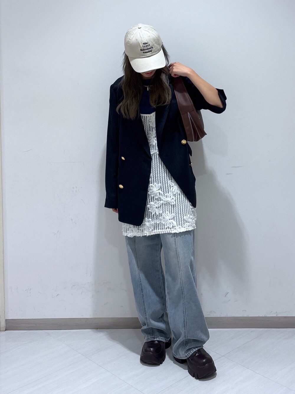 ブルー系のテーラードジャケット、ホワイト系のワンピース、ブルー系のデニムパンツを着用したレディースの夏コーディネートの2枚目の写真