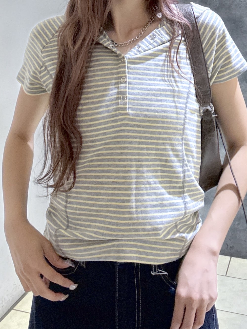 グレー系のTシャツ/カットソー、ブラウン系のショルダーバッグ、ブルー系のデニムパンツを着用したレディースの夏コーディネートの3枚目の写真