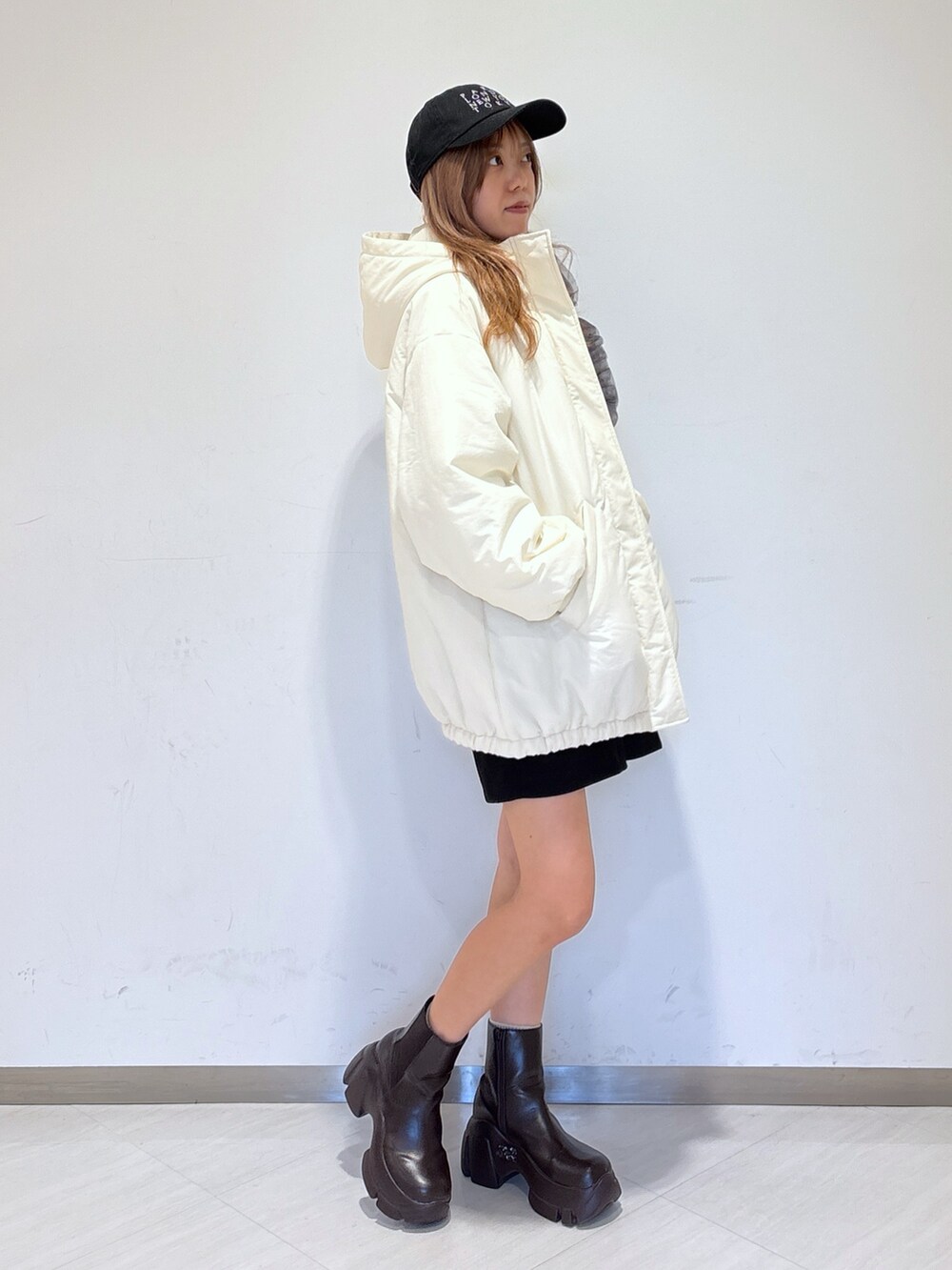 ホワイト系のニット/セーター、ブラック系のその他パンツ、ホワイト系のブルゾンを着用したレディースの冬コーディネートの5枚目の写真