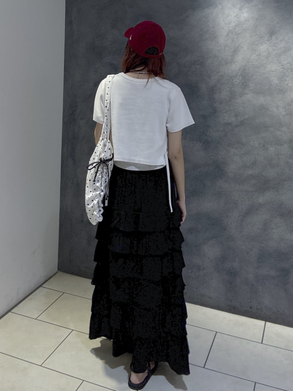 ホワイト系のTシャツ/カットソー、ブラック系のスカート、ブラック系のサンダルを着用したレディースの夏コーディネートの5枚目の写真