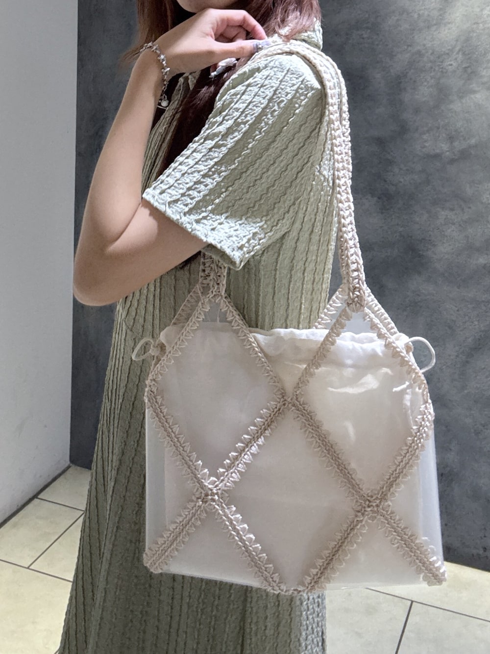 グリーン系のワンピース、ベージュ系のトートバッグ、ブラウン系のサンダルを着用したレディースの夏コーディネートの5枚目の写真