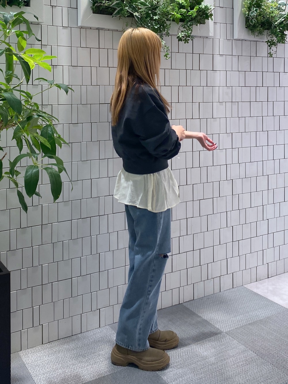 ブラック系のスウェット、ホワイト系のシャツ/ブラウス、ブルー系のデニムパンツを着用したレディースの冬コーディネートの2枚目の写真