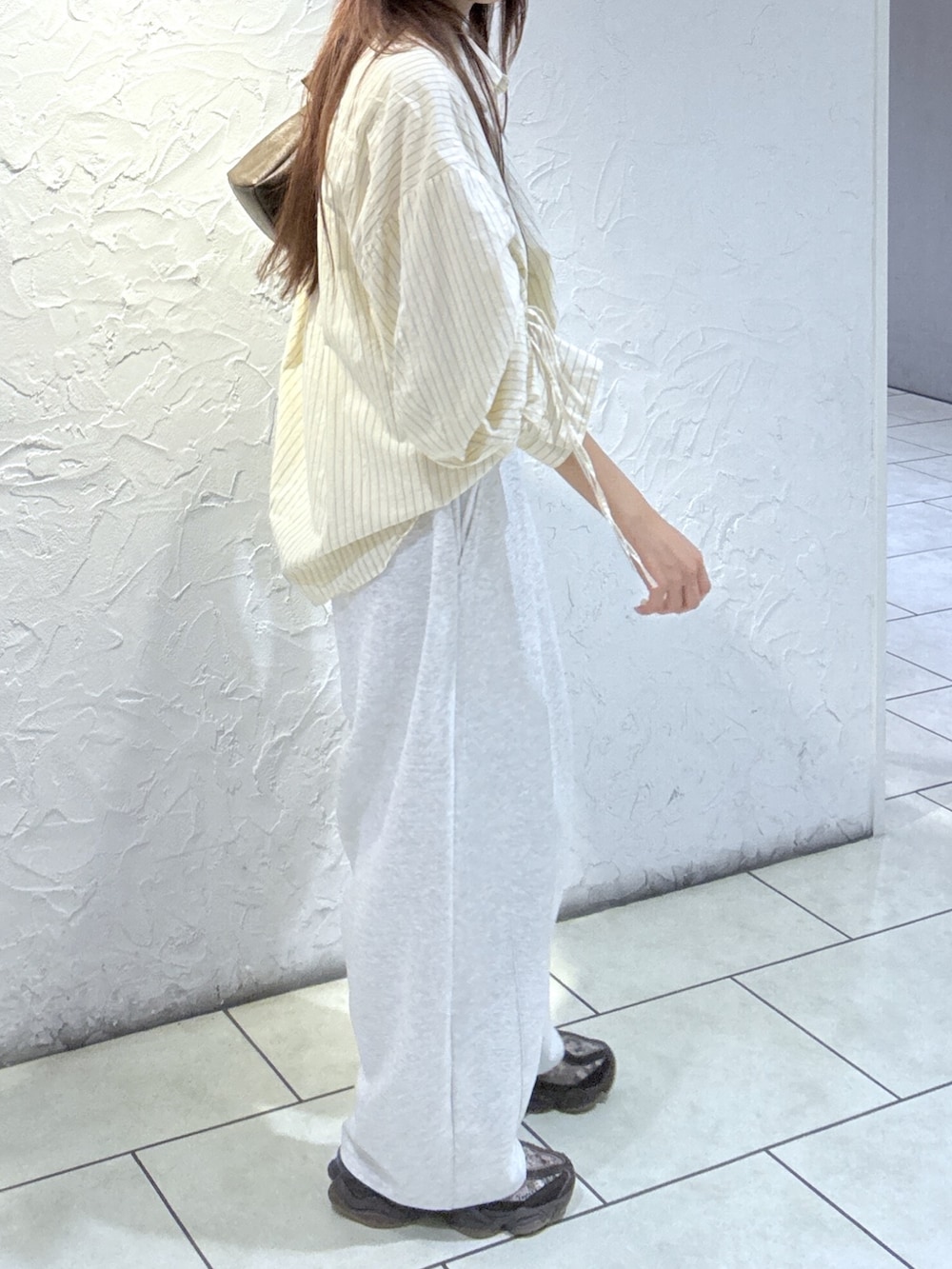 ホワイト系のその他パンツ、ホワイト系のシャツ/ブラウス、ブラック系のショルダーバッグを着用したレディースの夏コーディネートの2枚目の写真