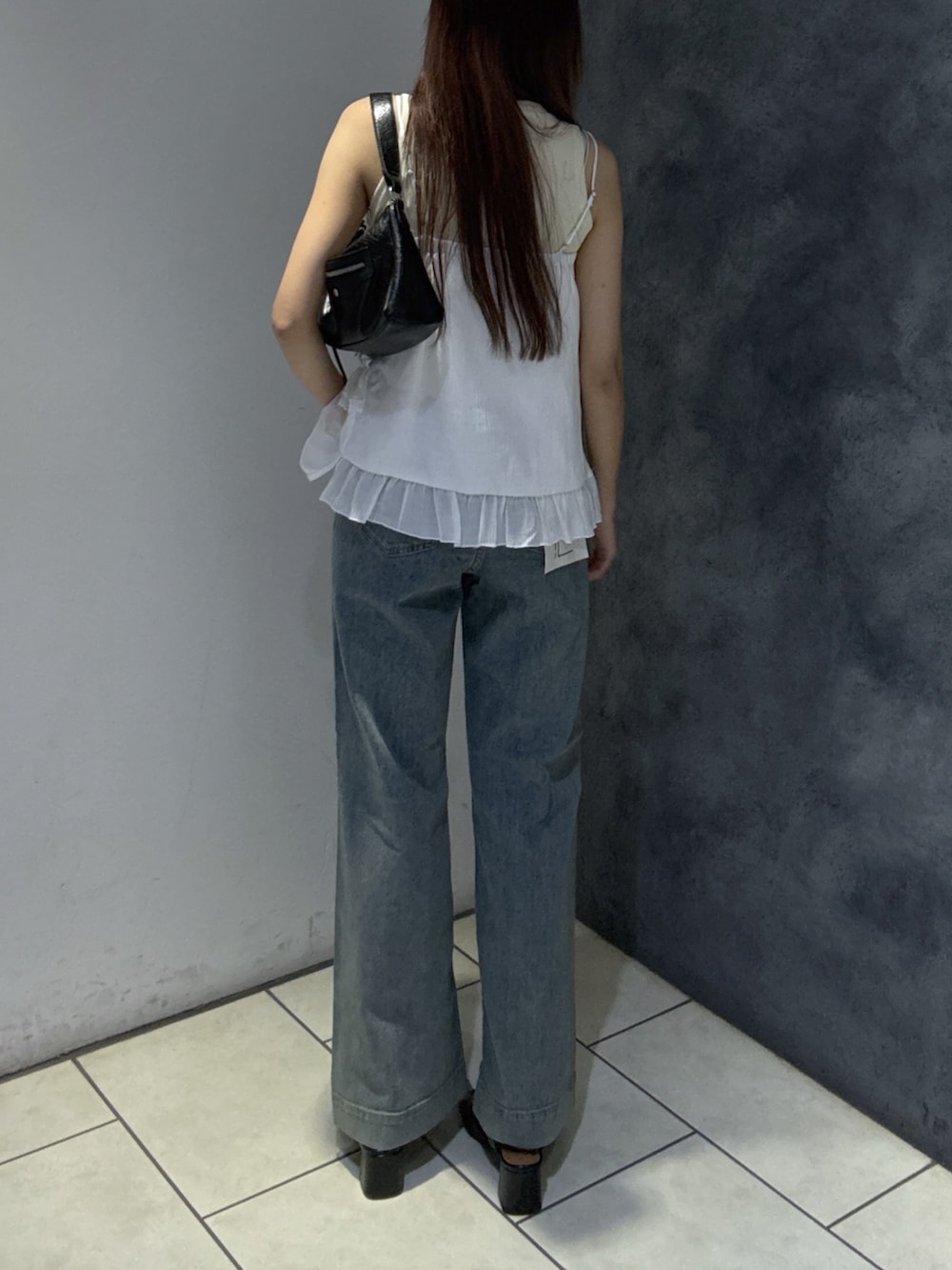 ホワイト系のTシャツ/カットソー、ブルー系のデニムパンツ、ブラック系のショルダーバッグを着用したレディースの夏コーディネートの4枚目の写真