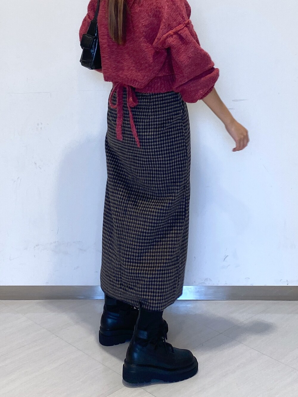 ブラック系のブーツ、ブラック系のハンドバッグ、ピンク系のニット/セーターを着用したレディースの秋コーディネートの8枚目の写真