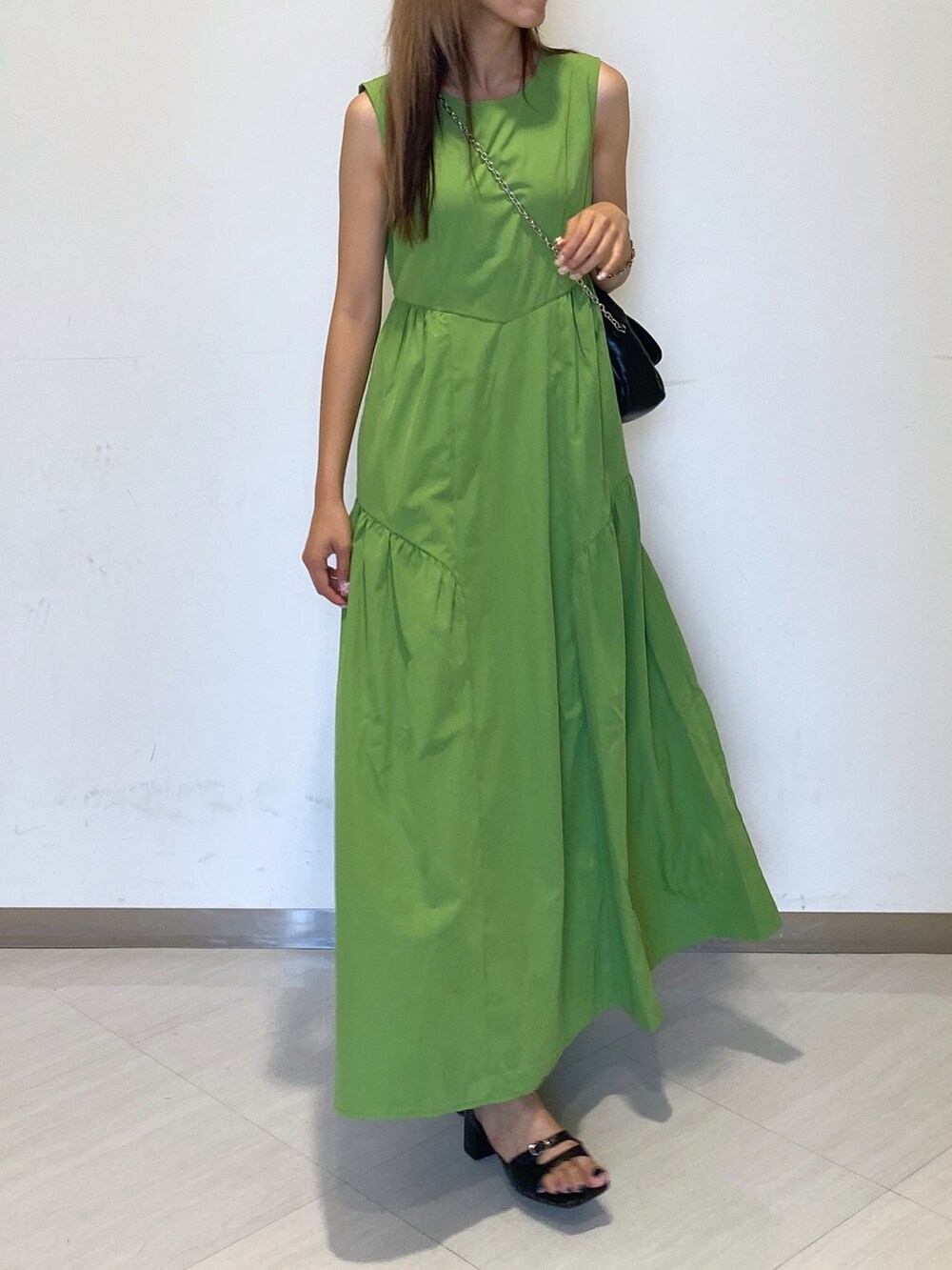 ブラック系のショルダーバッグ、グリーン系のワンピース、ブラック系のサンダルを着用したレディースの夏コーディネートの4枚目の写真