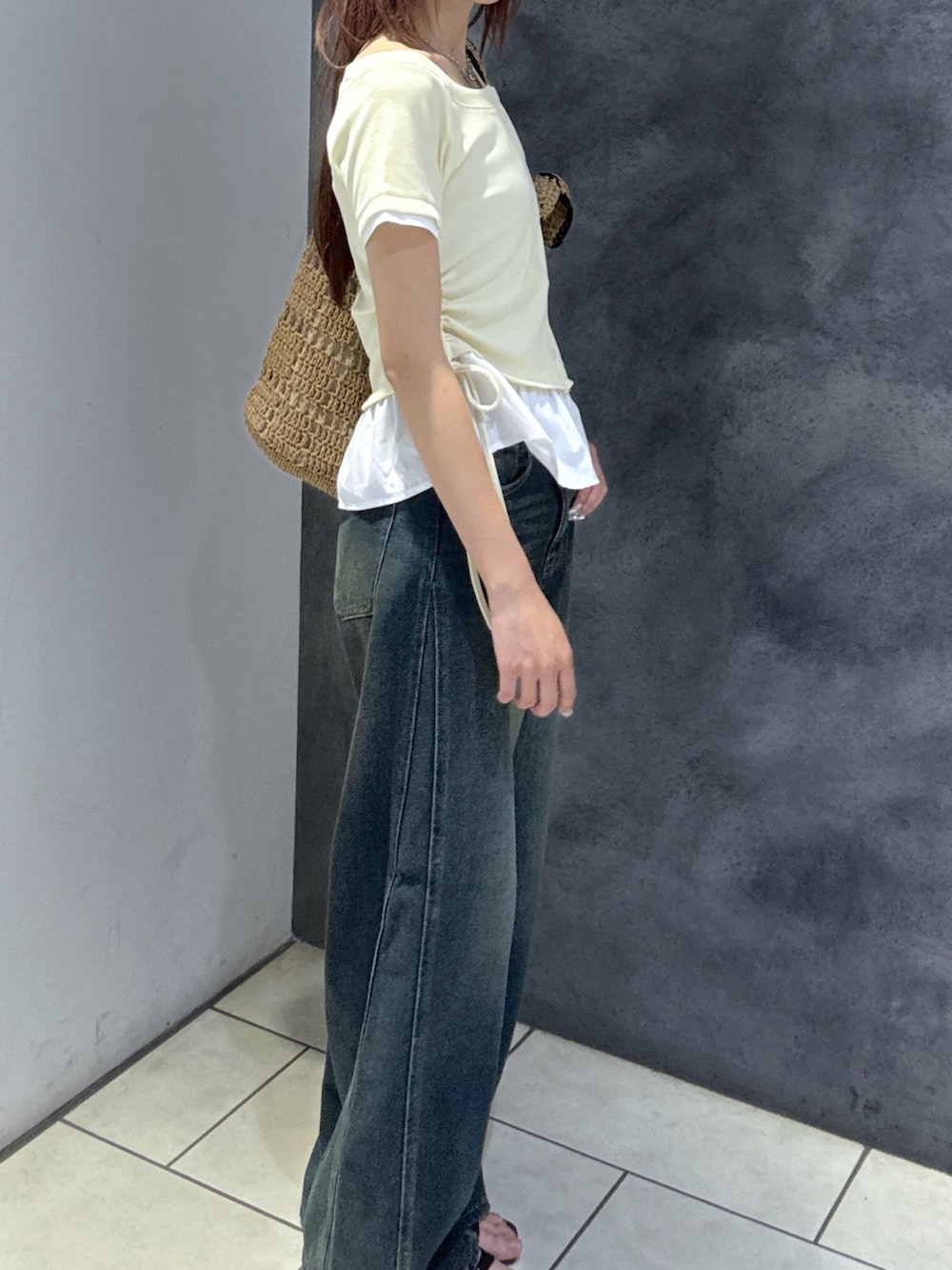 ブルー系のデニムパンツ、ブラック系のサンダル、ホワイト系のTシャツ/カットソーを着用したレディースの夏コーディネートの5枚目の写真