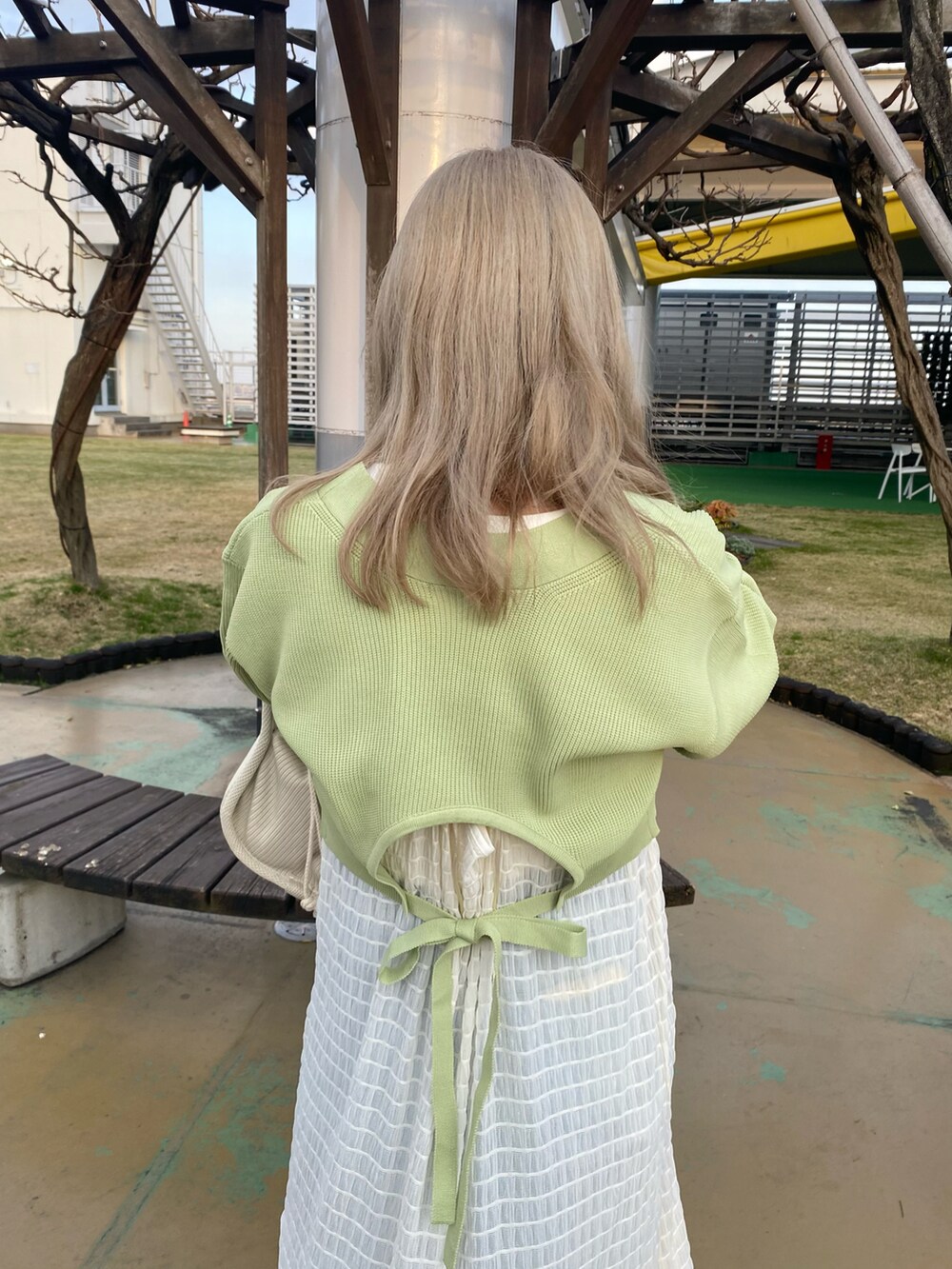 グリーン系のカーディガン/ボレロ、ホワイト系のTシャツ/カットソー、ホワイト系のワンピースを着用したレディースの春コーディネートの3枚目の写真