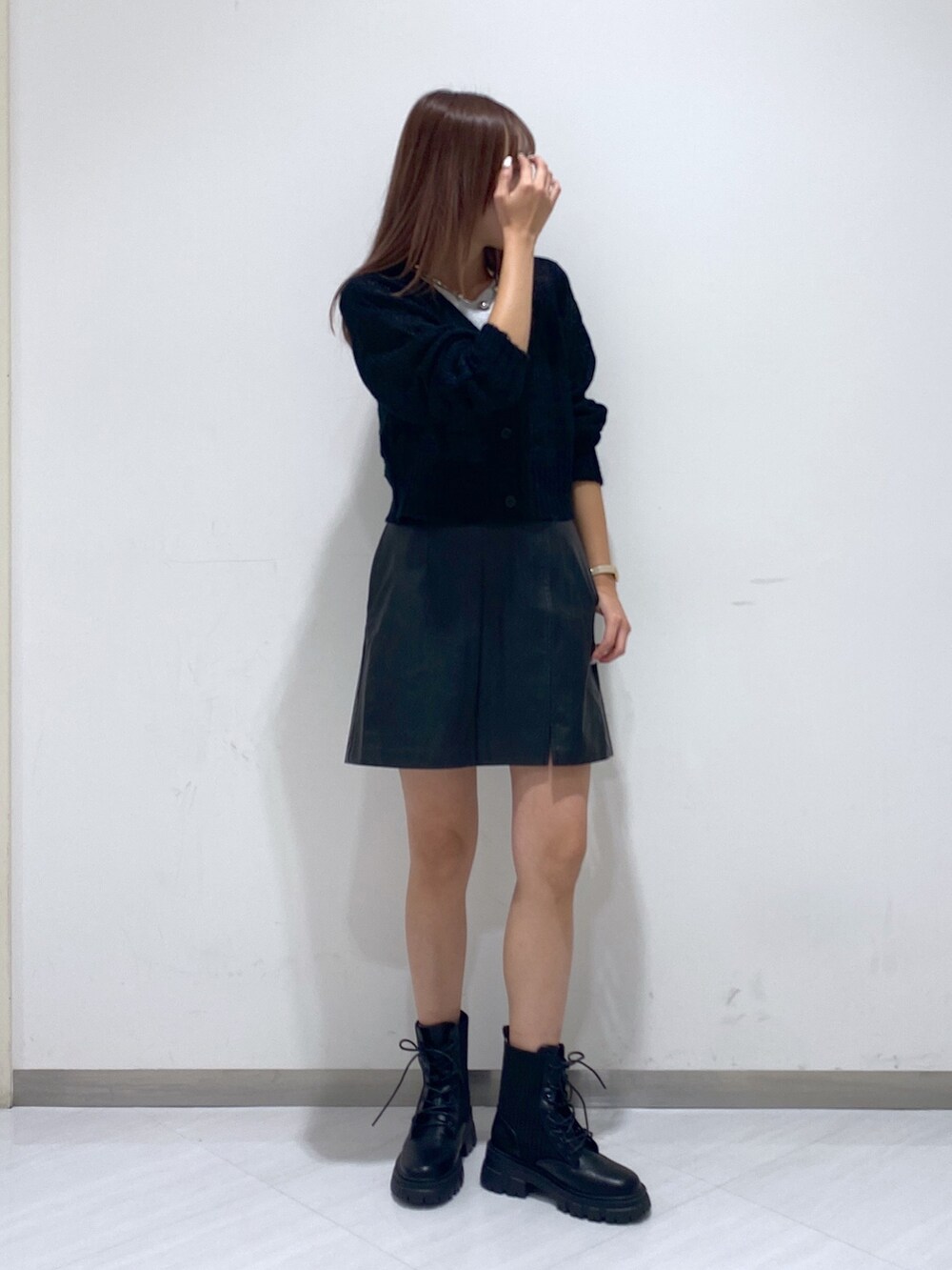 ブラック系のカーディガン/ボレロ、ブラック系のスカート、ブラック系のブーツを着用したレディースの秋コーディネートの2枚目の写真