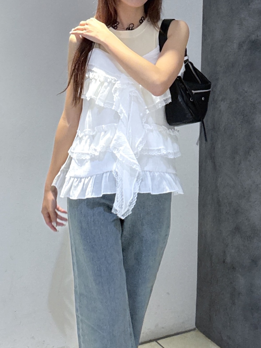 ホワイト系のTシャツ/カットソー、ブルー系のデニムパンツ、ブラック系のショルダーバッグを着用したレディースの夏コーディネートの2枚目の写真