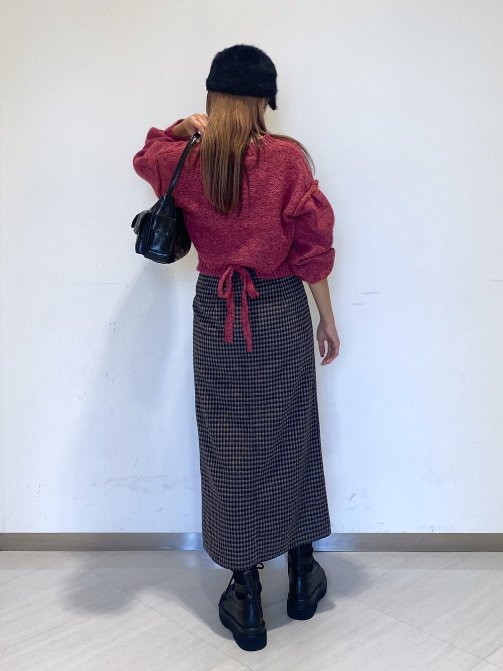 ブラック系のブーツ、ブラック系のハンドバッグ、ピンク系のニット/セーターを着用したレディースの秋コーディネートの5枚目の写真