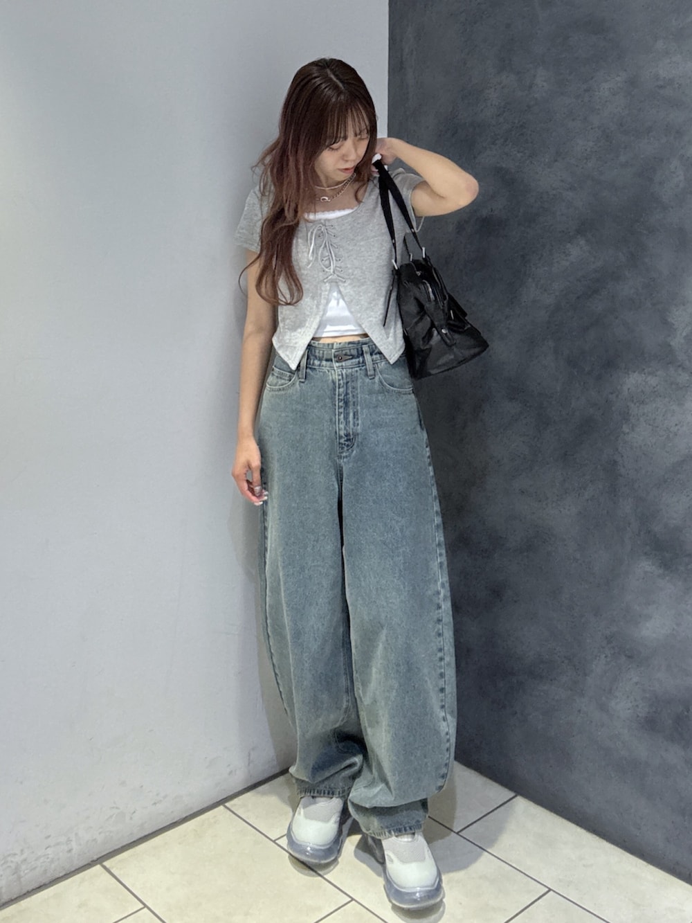 ブラック系のショルダーバッグ、グレー系のTシャツ/カットソー、ブルー系のデニムパンツを着用したレディースの夏コーディネートの2枚目の写真
