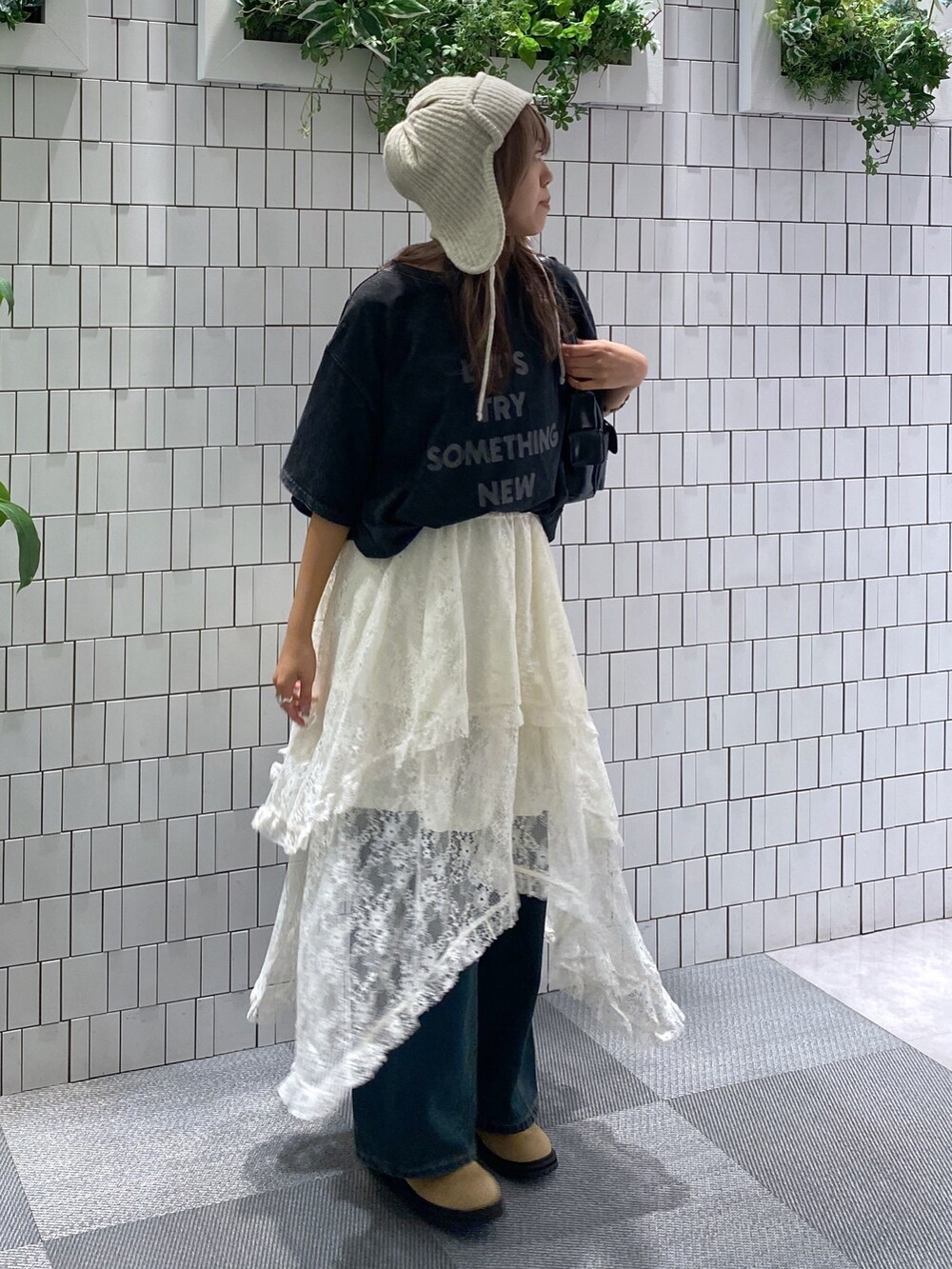 ブラック系のTシャツ/カットソー、ブラック系のハンドバッグ、ホワイト系のスカートを着用したレディースの秋コーディネートの2枚目の写真
