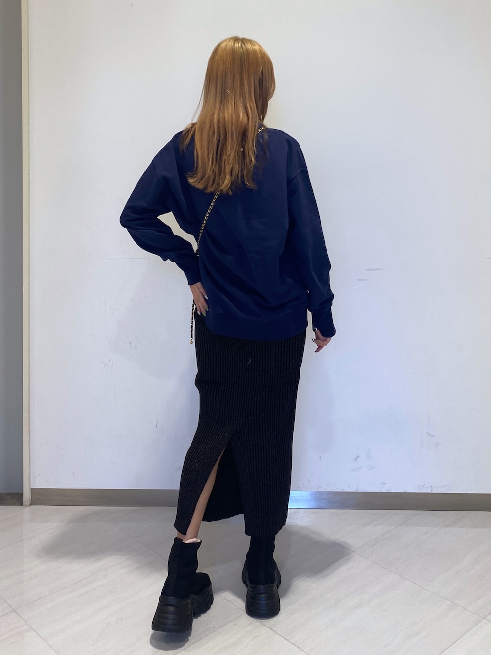 ブルー系のスウェット、ブラック系のスカート、ブラック系のショルダーバッグを着用したレディースの冬コーディネートの2枚目の写真