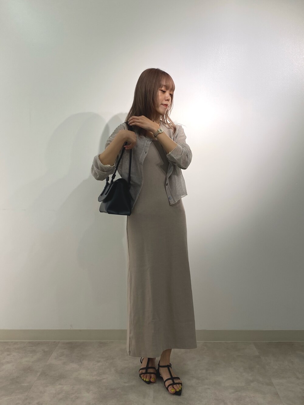 ベージュ系のワンピース、ホワイト系のカーディガン/ボレロ、ブラック系のショルダーバッグを着用したレディースの夏コーディネートの2枚目の写真