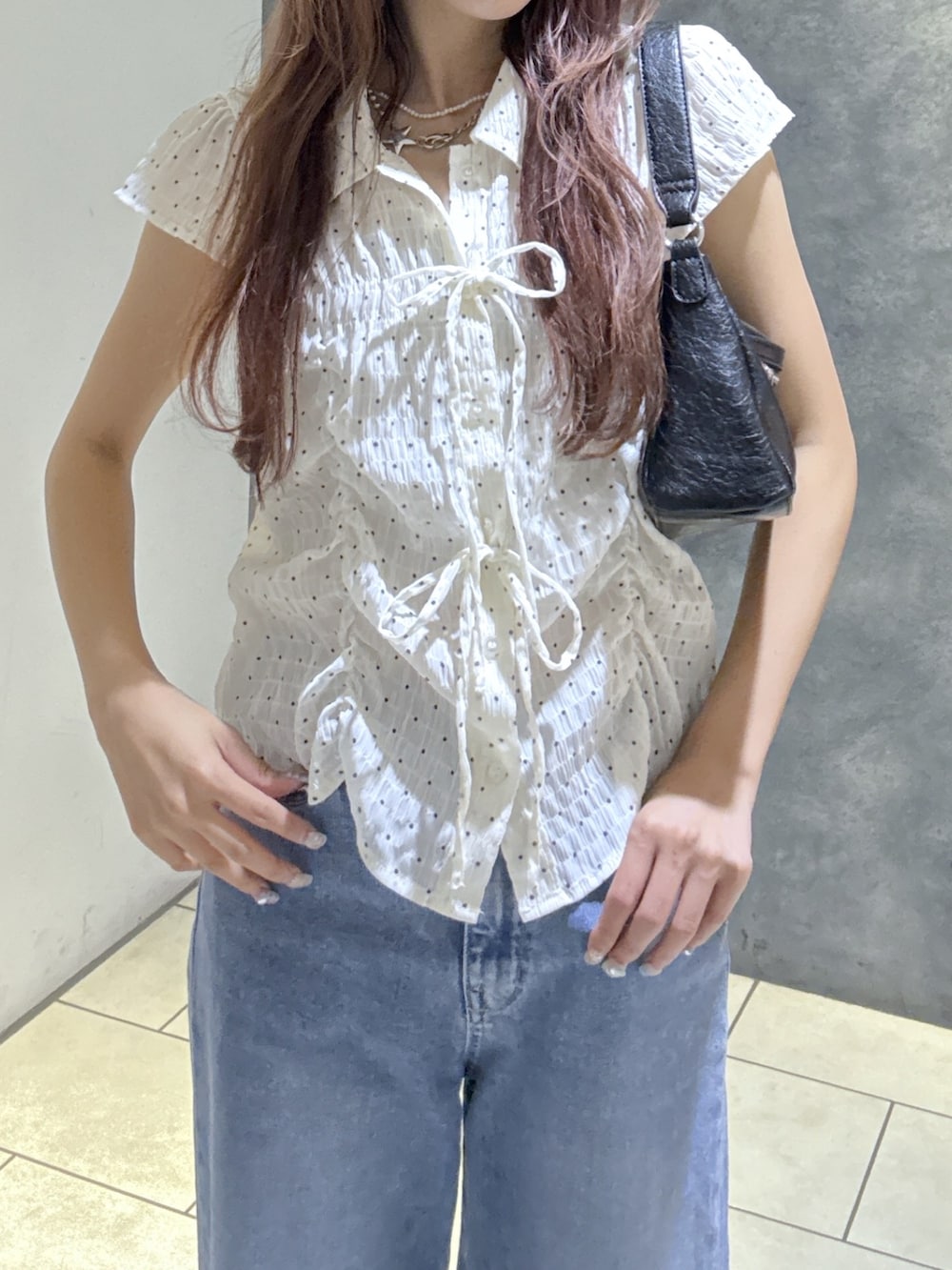 ホワイト系のシャツ/ブラウス、ブルー系のデニムパンツ、ブラック系のショルダーバッグを着用したレディースの夏コーディネートの2枚目の写真