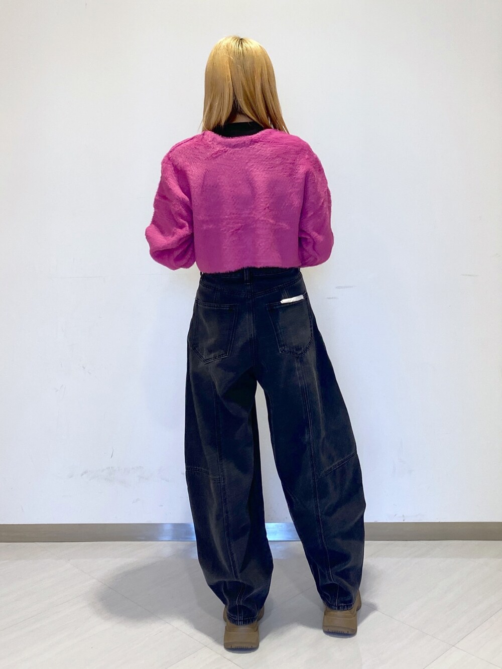 ピンク系のカーディガン/ボレロ、ブラック系のデニムパンツを着用したレディースの冬コーディネートの2枚目の写真