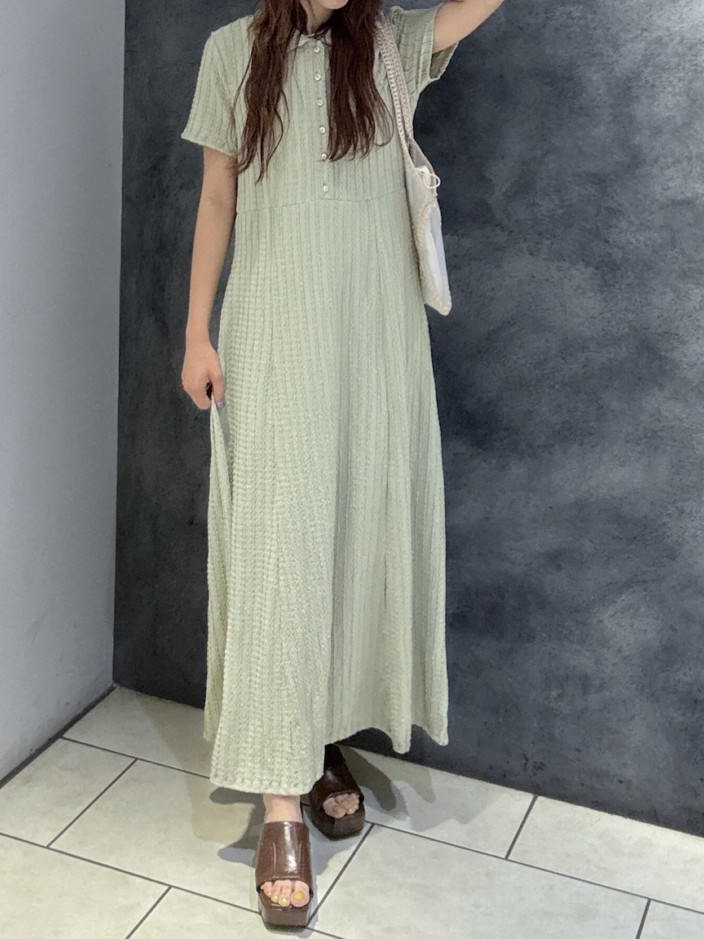 グリーン系のワンピース、ベージュ系のトートバッグ、ブラウン系のサンダルを着用したレディースの夏コーディネートの2枚目の写真