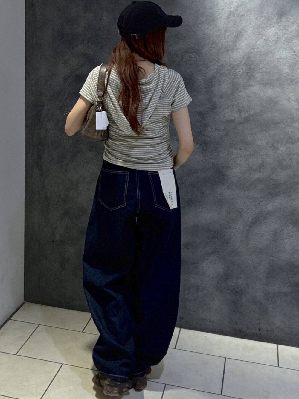 グレー系のTシャツ/カットソー、ブラウン系のショルダーバッグ、ブルー系のデニムパンツを着用したレディースの夏コーディネートの5枚目の写真