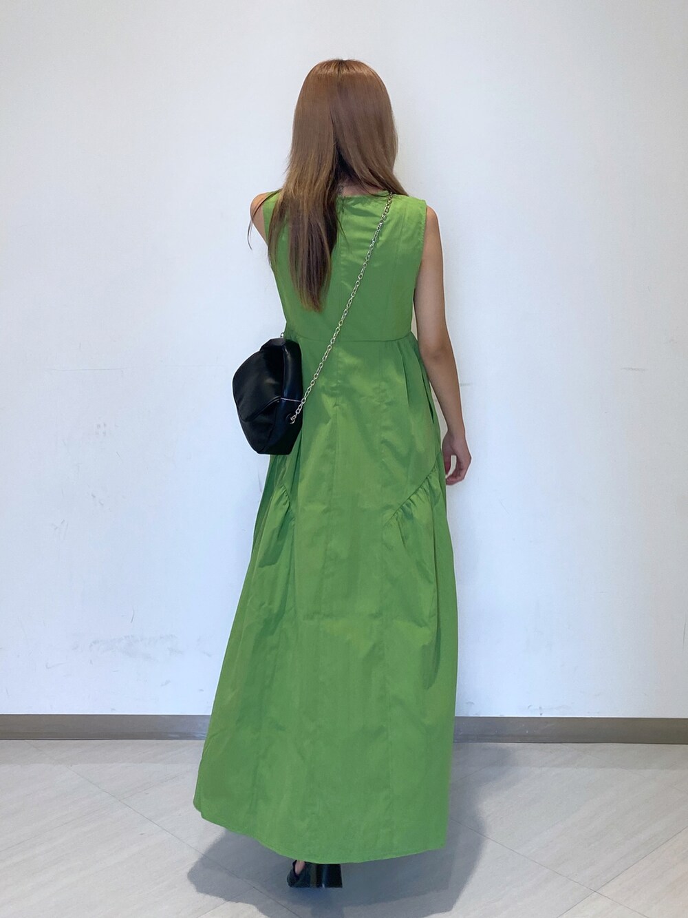 ブラック系のショルダーバッグ、グリーン系のワンピース、ブラック系のサンダルを着用したレディースの夏コーディネートの3枚目の写真