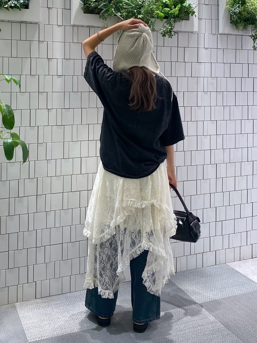 ブラック系のTシャツ/カットソー、ブラック系のハンドバッグ、ホワイト系のスカートを着用したレディースの秋コーディネートの5枚目の写真