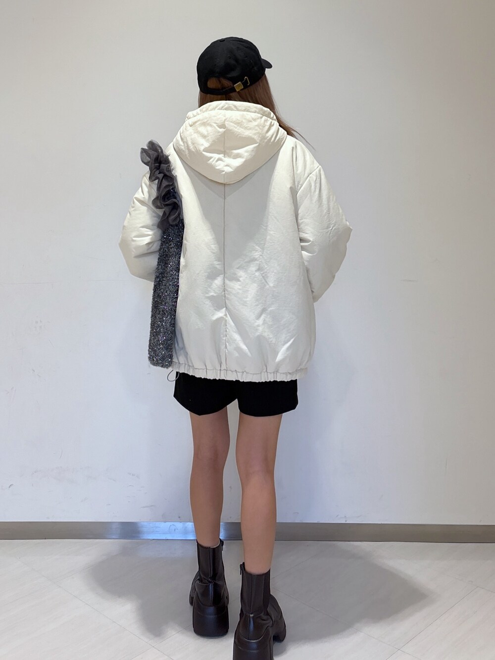 ホワイト系のニット/セーター、ブラック系のその他パンツ、ホワイト系のブルゾンを着用したレディースの冬コーディネートの8枚目の写真