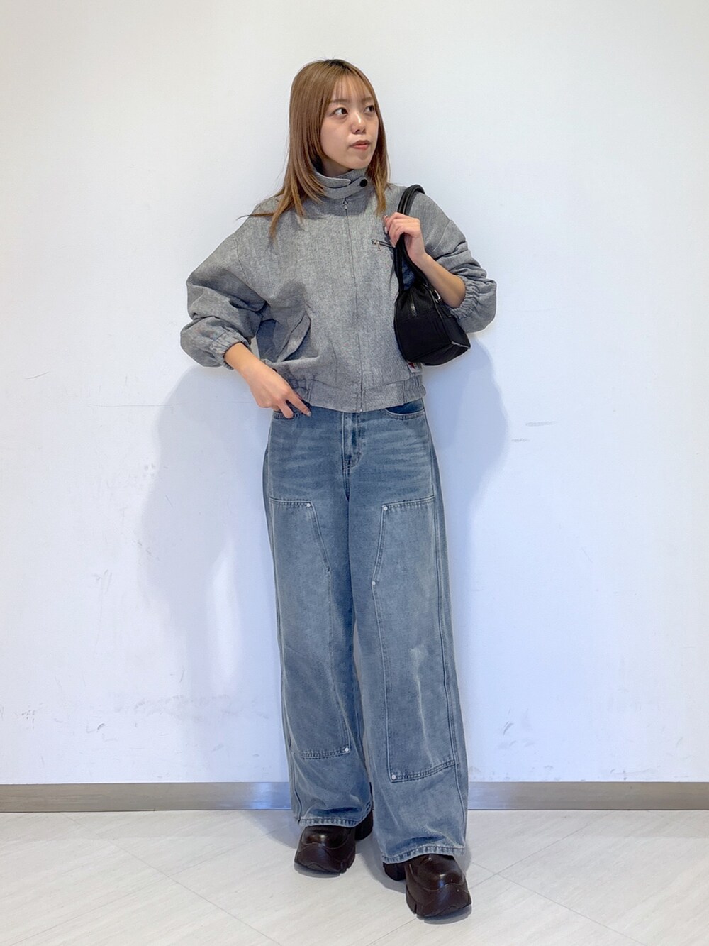グレー系のその他アウター、ブルー系のデニムパンツ、ブラック系のトートバッグを着用したレディースの冬コーディネートの2枚目の写真