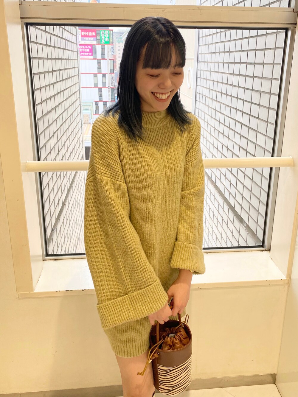 ホワイト系のブーツ、ベージュ系のショルダーバッグ、グリーン系のワンピースを着用したレディースの秋コーディネートの2枚目の写真