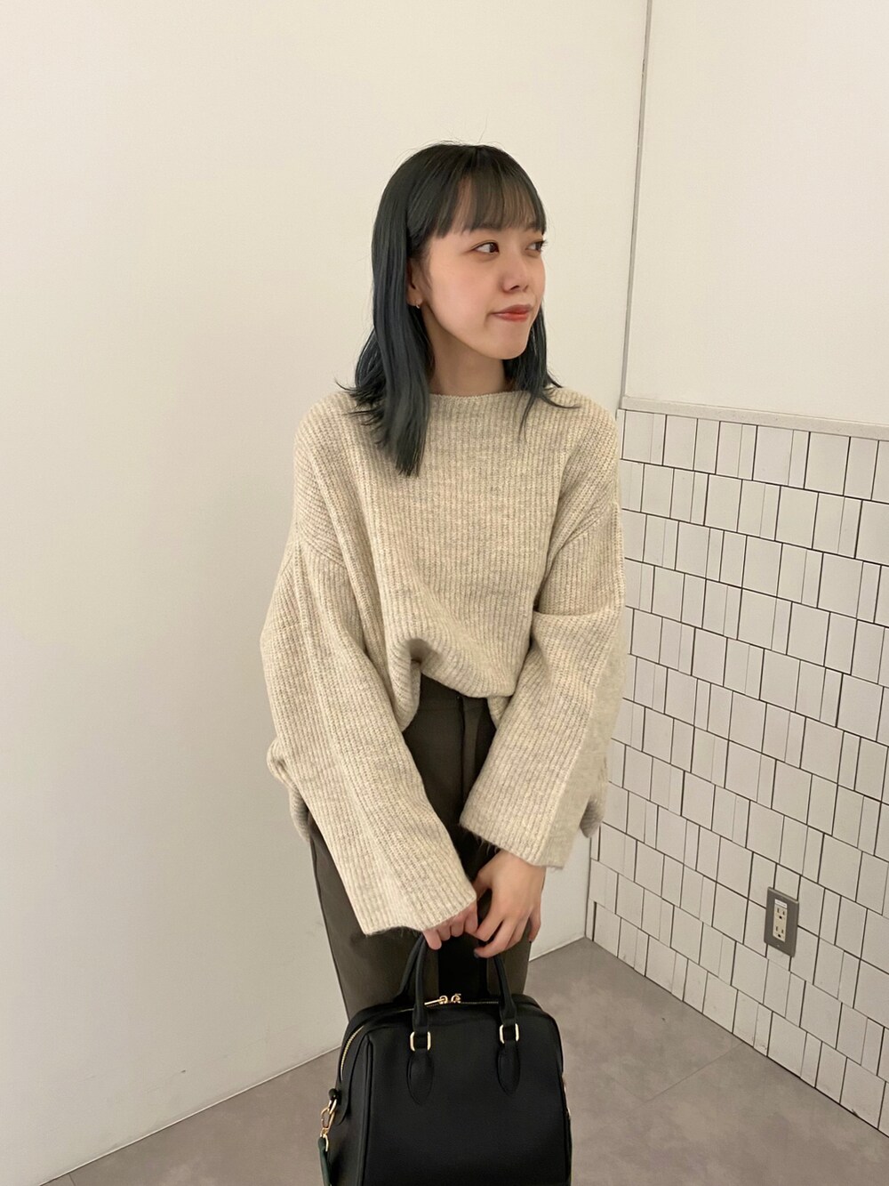 ブラック系のボストンバッグ、ホワイト系のニット/セーター、ブラウン系のその他パンツを着用したレディースの秋コーディネートの3枚目の写真