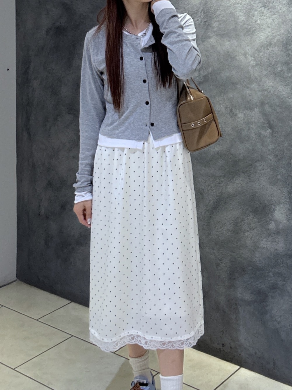 グレー系のTシャツ/カットソー、ブラウン系のショルダーバッグ、ブルー系のスニーカーを着用したレディースの春コーディネートの4枚目の写真