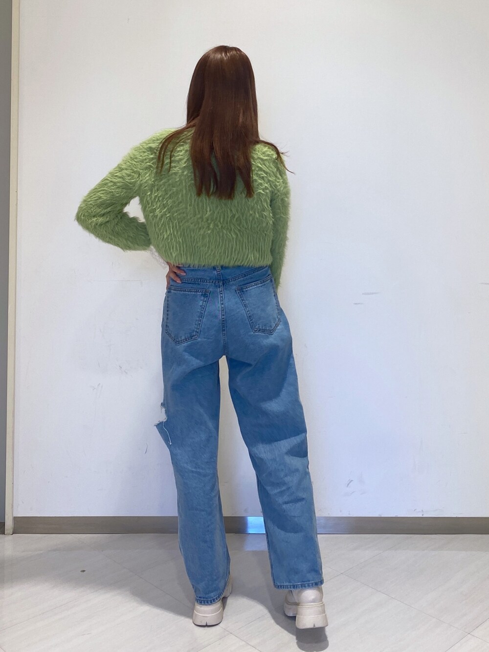 グリーン系のカーディガン/ボレロ、ホワイト系のTシャツ/カットソー、ブルー系のデニムパンツを着用したレディースの秋コーディネートの2枚目の写真