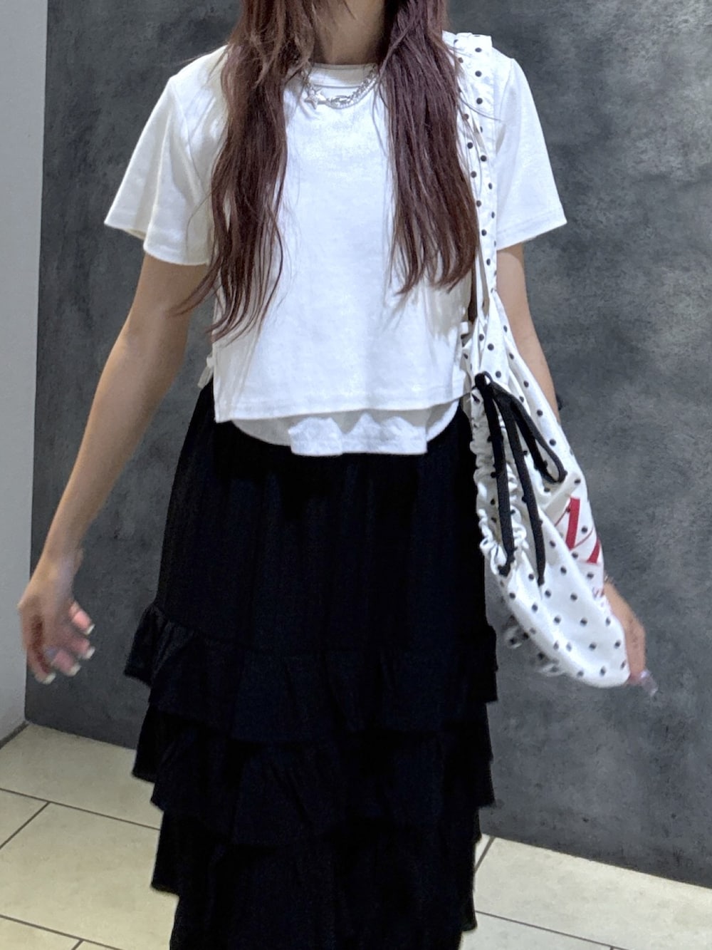 ホワイト系のTシャツ/カットソー、ブラック系のスカート、ブラック系のサンダルを着用したレディースの夏コーディネートの3枚目の写真