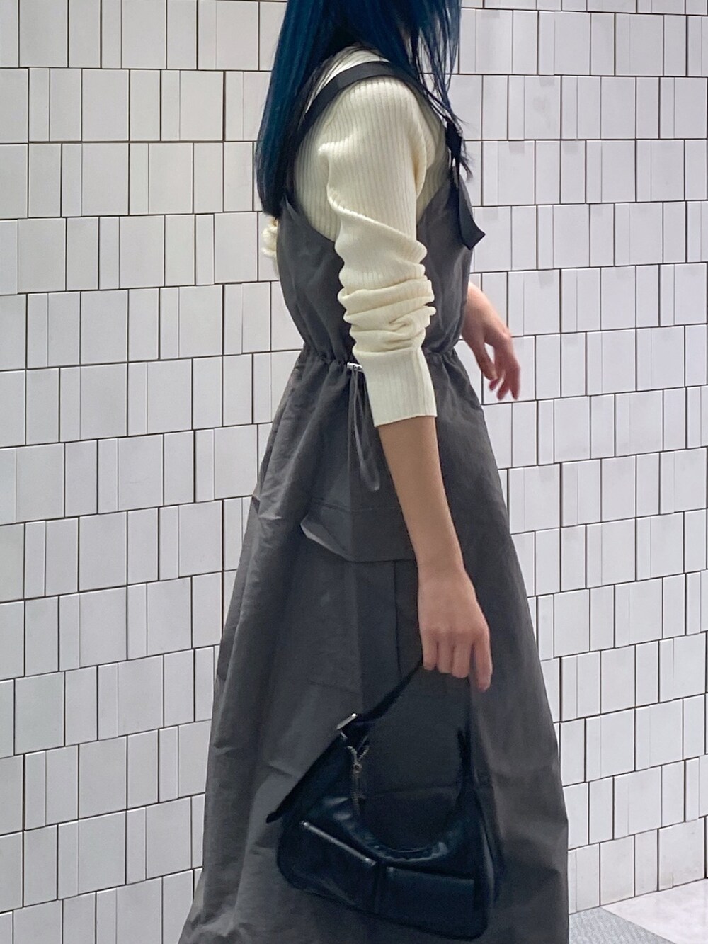 ホワイト系のニット/セーター、グレー系のワンピース、ブラック系のショルダーバッグを着用したレディースの春コーディネートの2枚目の写真